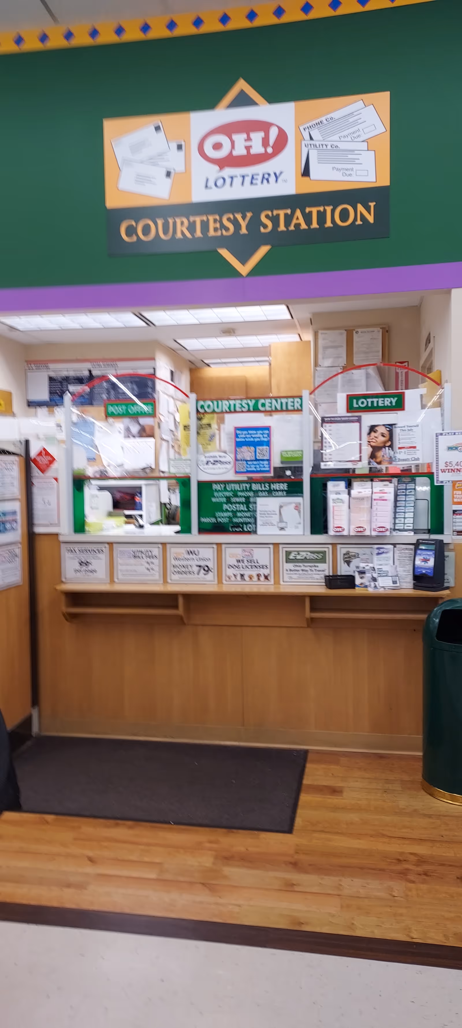 Inside Discount Drug Mart, a courtesy station with lottery signs by the service counter.