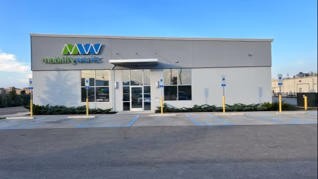 The exterior front of a MobilityWorks building with parking spaces and blue handicap spots.