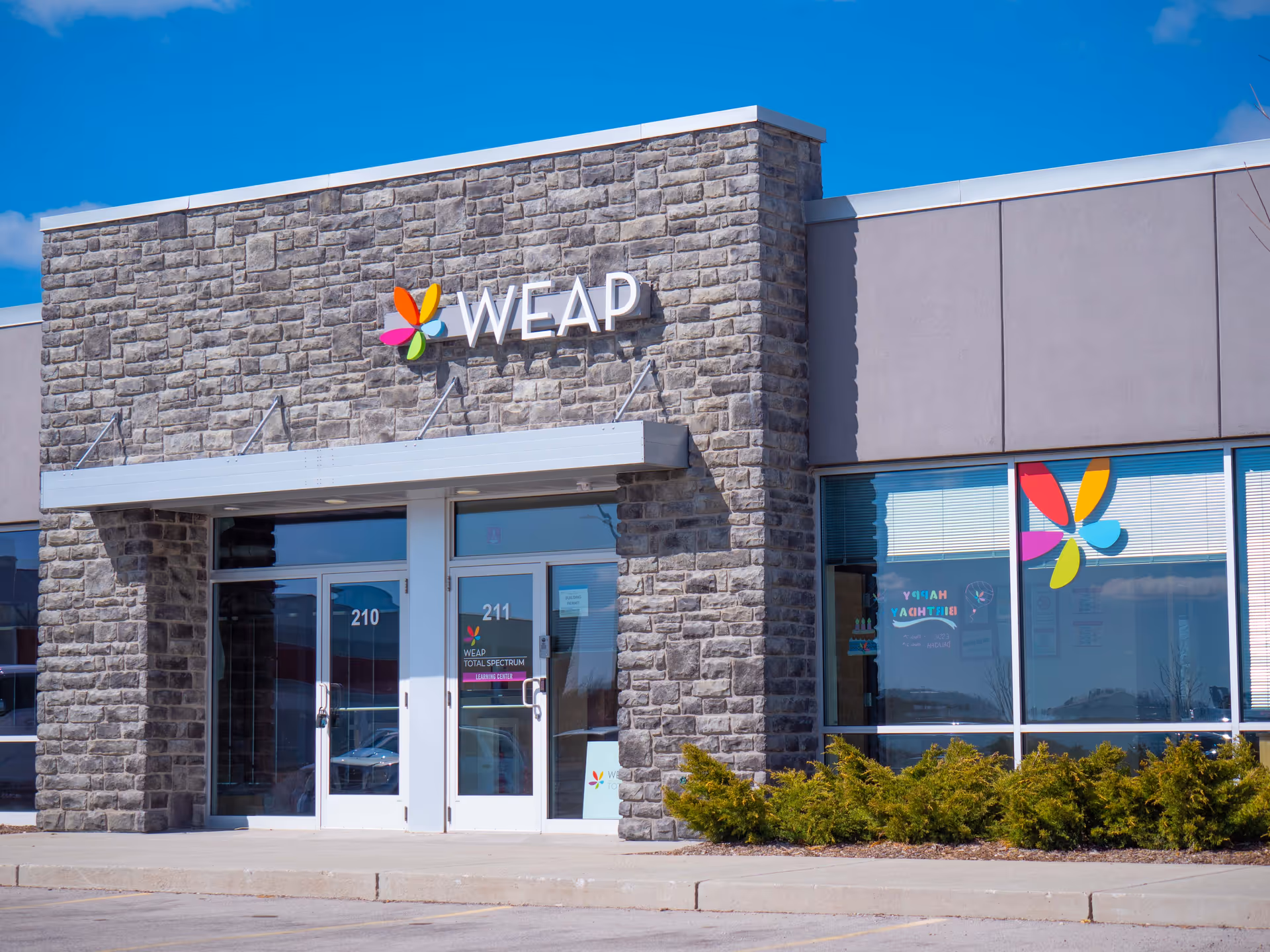Exterior view of a WEAP building with a stone facade and glass entrance.