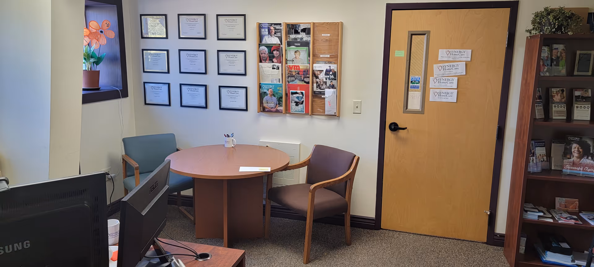 Interior office/waiting area at a SYNERGY HomeCare facility with a round table.