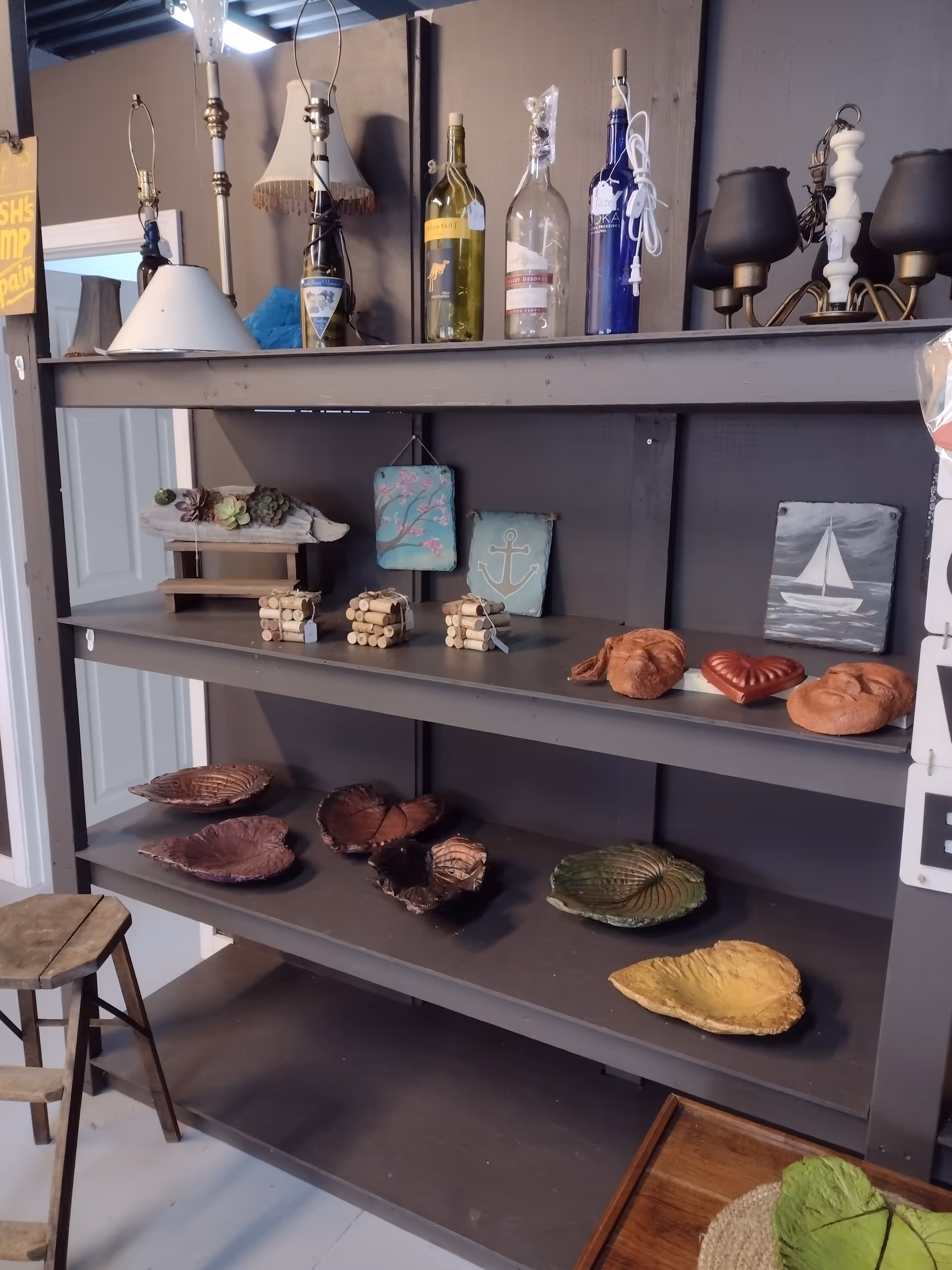 Indoor shelving with bottles, nautical art, and seashell decorations.