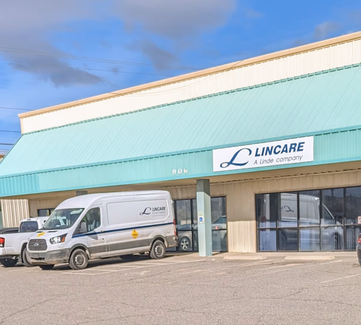Exterior of a Lincare facility with teal awning, sign, and service van in parking.