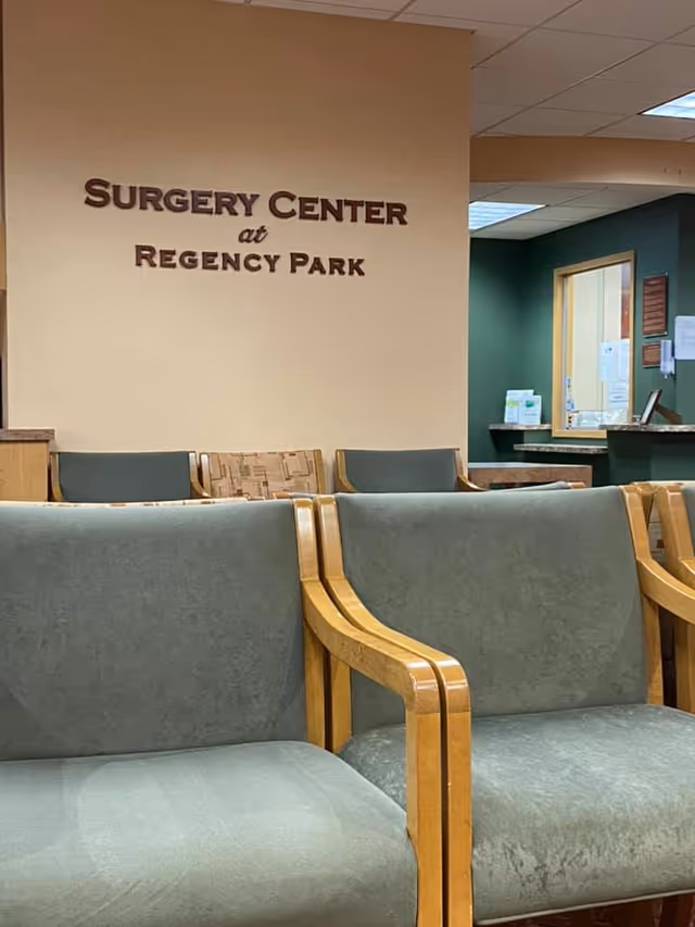 Lobby seating area with green chairs and a sign reading Surgery Center at Regency Park.