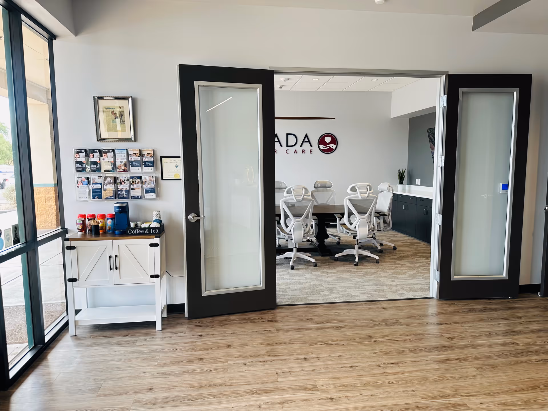Double doors open to a modern conference room with white chairs around a dark table.
