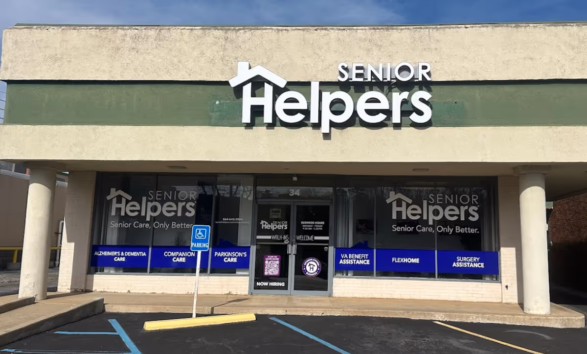 Exterior view of a Senior Helpers storefront with large sign and glass windows.