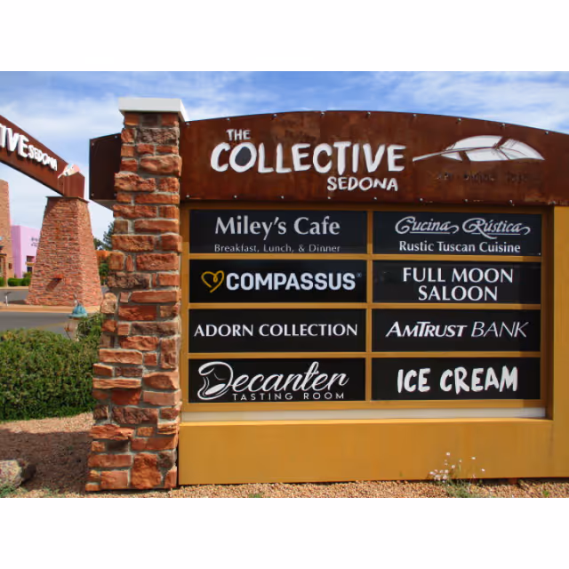 Outdoor signboard with multiple business signs including Compassus and Miley's Cafe