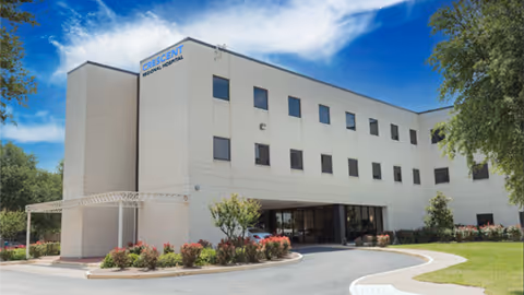 White multi-story Crescent Regional Hospital exterior with curved driveway and landscaped entrance.