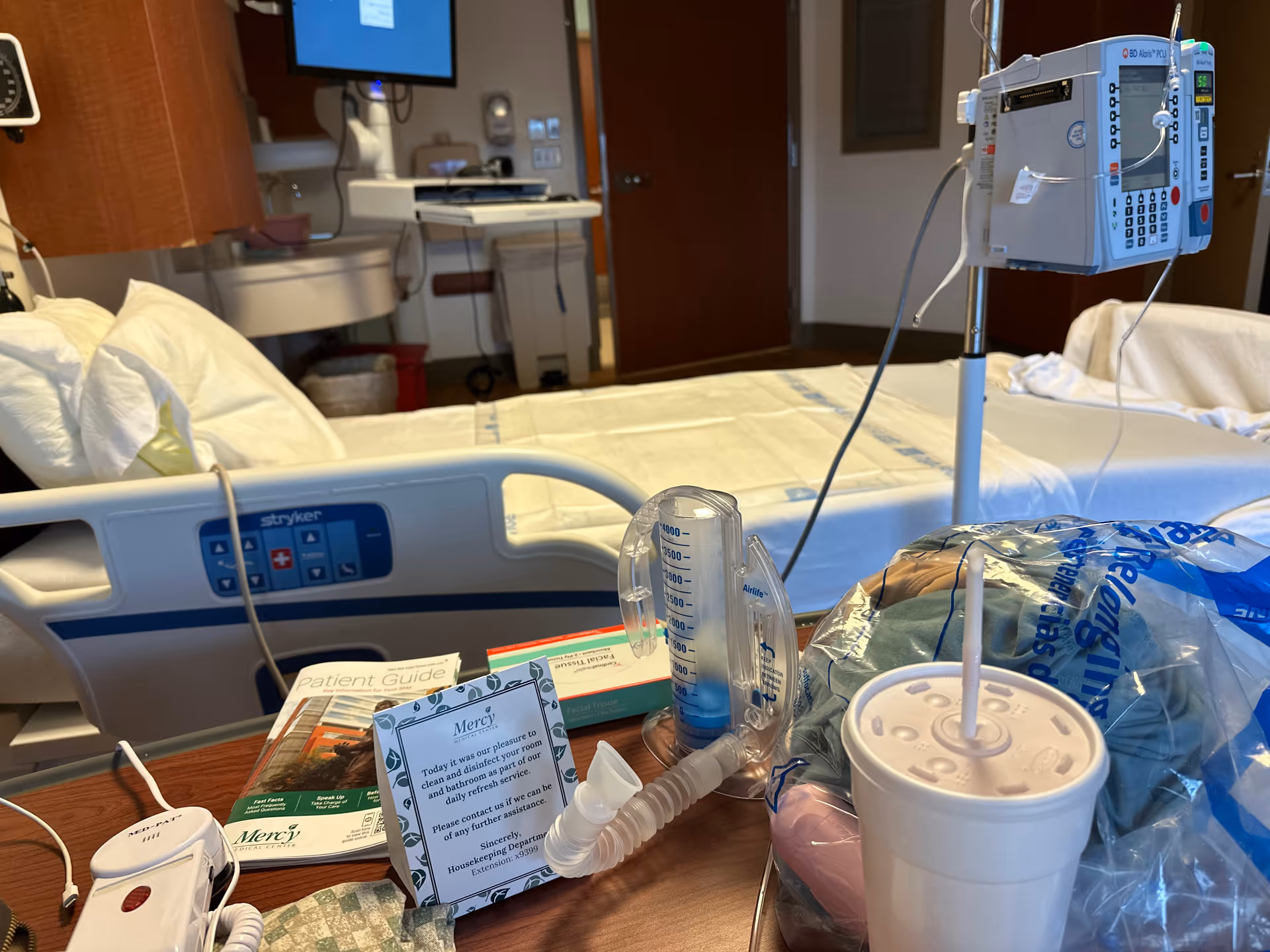 Mercy Medical Center patient room with bed, IV pole, monitors, and supplies.