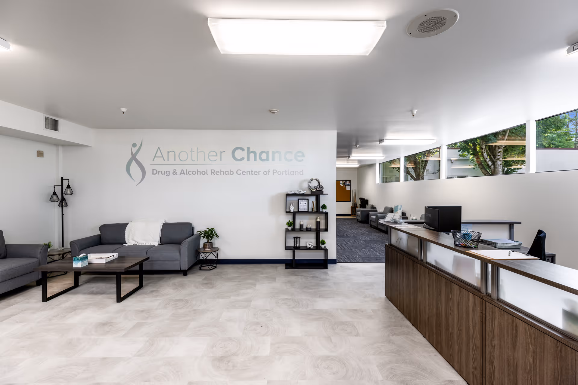 Bright lobby with sofas, a reception desk, and 'Another Chance' sign on the wall.