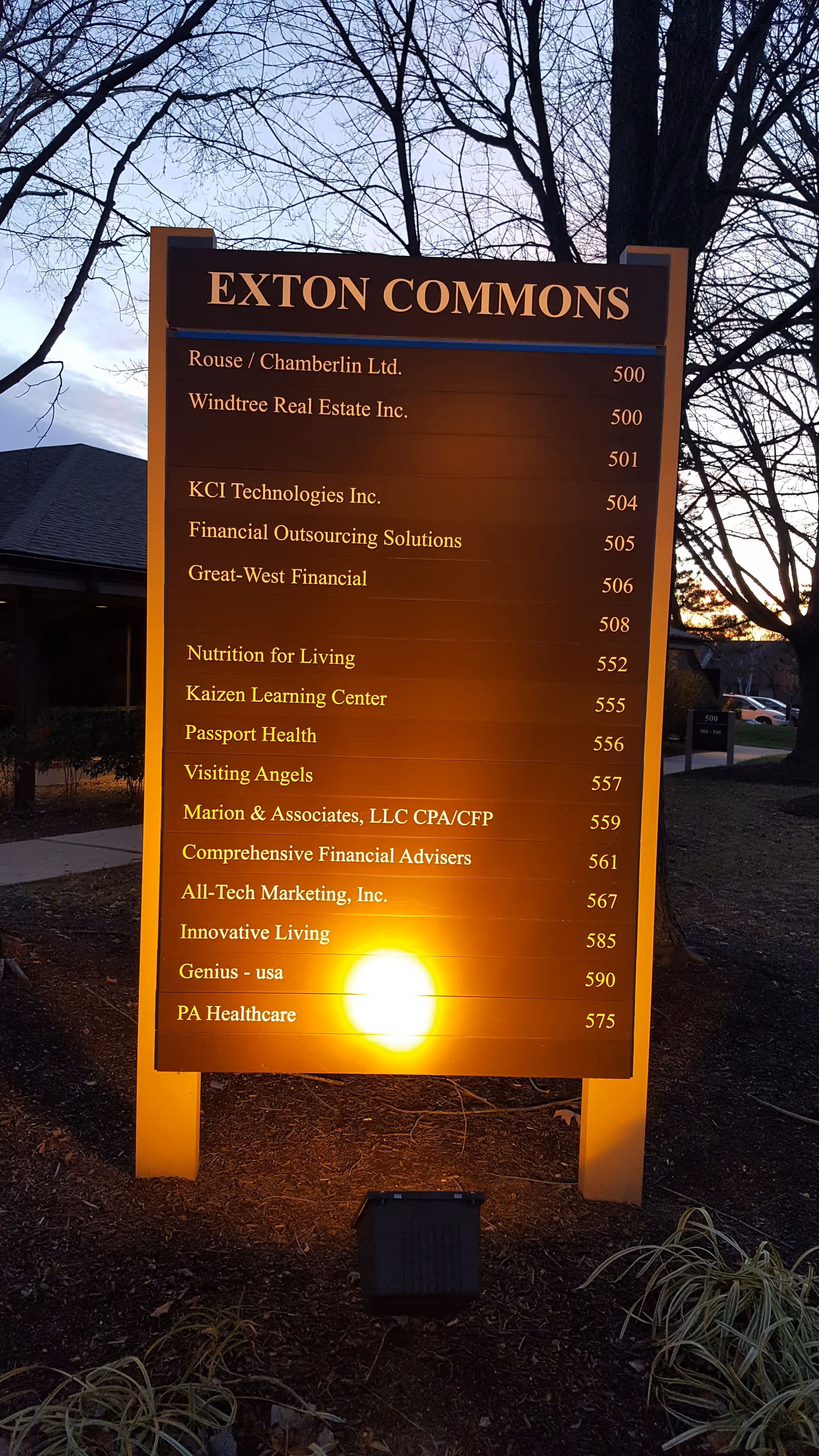Outdoor sign reading EXTON COMMONS with a directory of tenant names, including Visiting Angels.