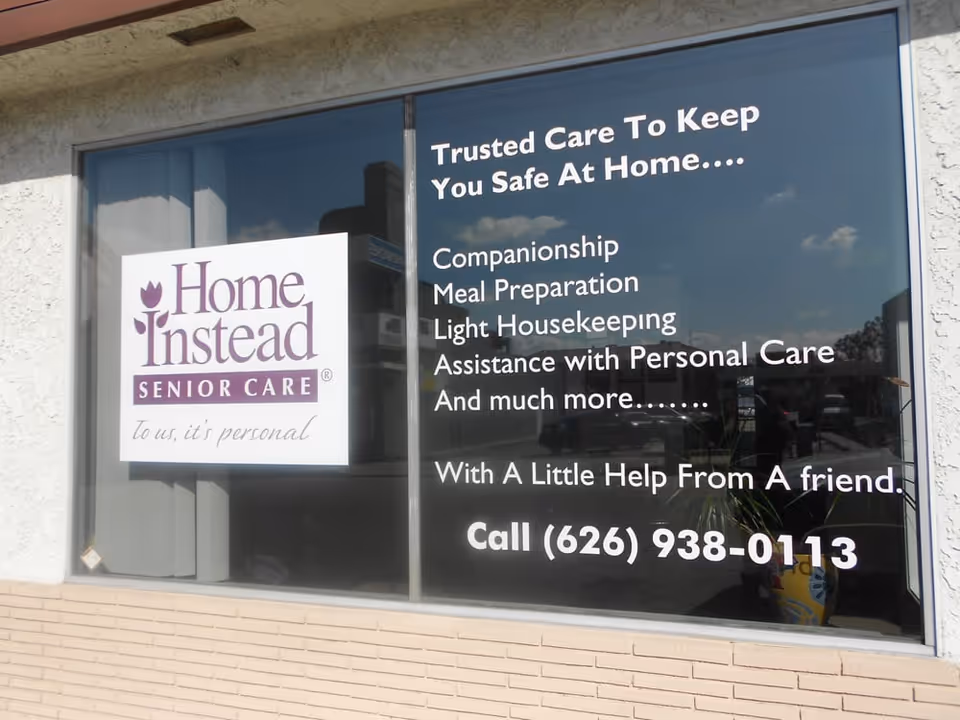 Exterior storefront windows display Home Instead Senior Care signage and service information.