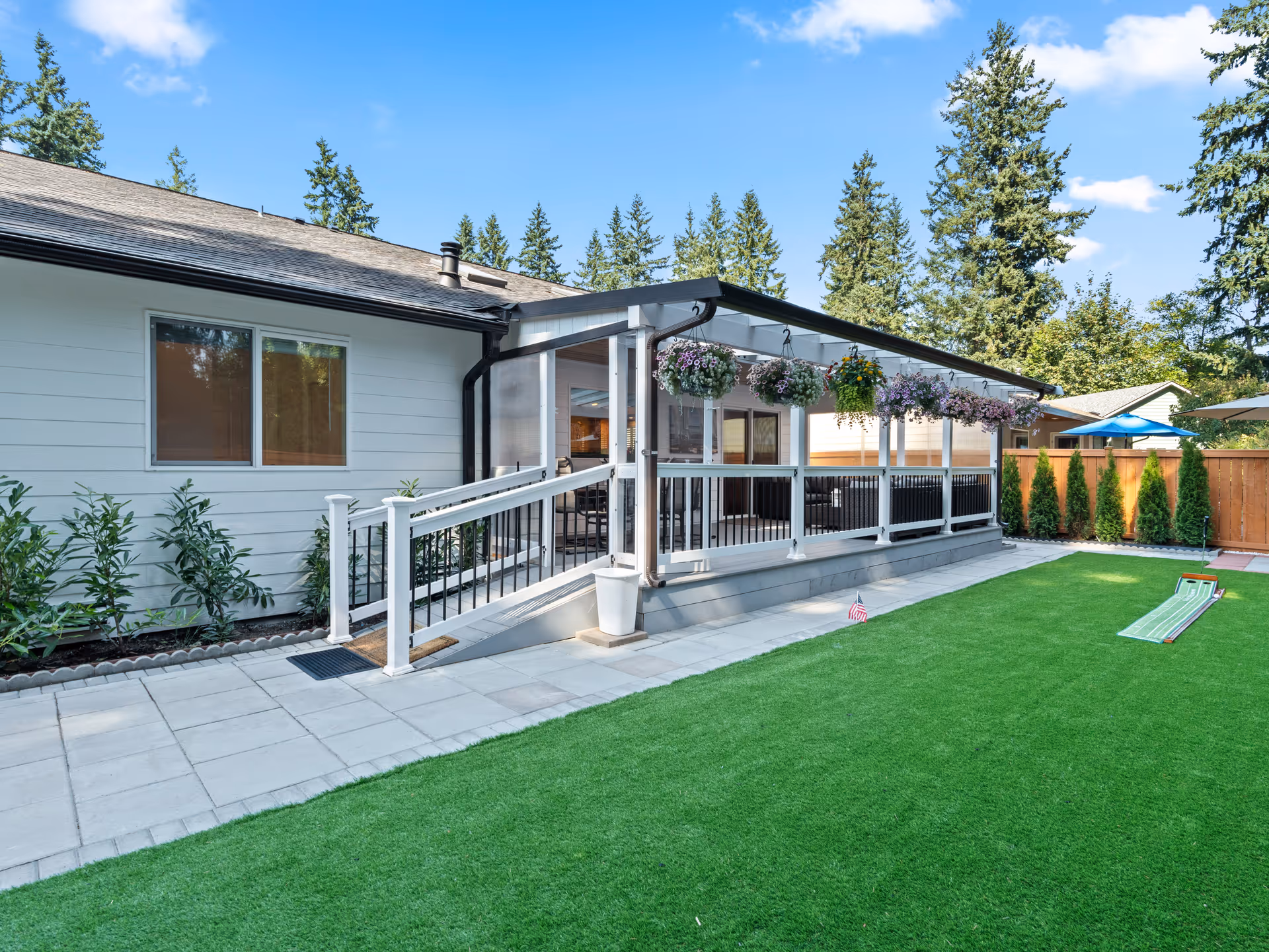 Single-story facility with a covered porch, hanging planters, and a green lawn.