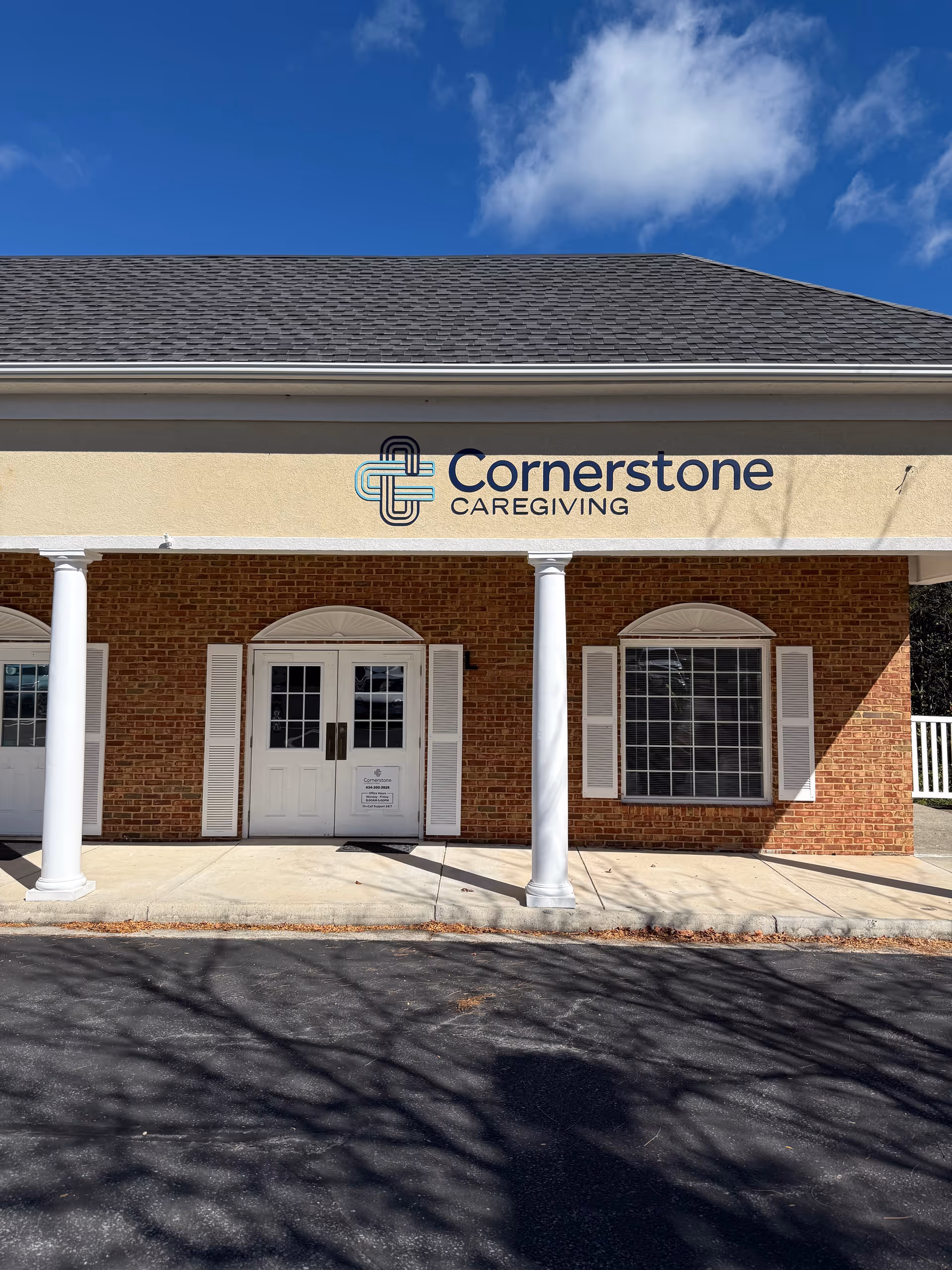 Front view of Cornerstone Caregiving building with brick exterior, white columns, and entrance.