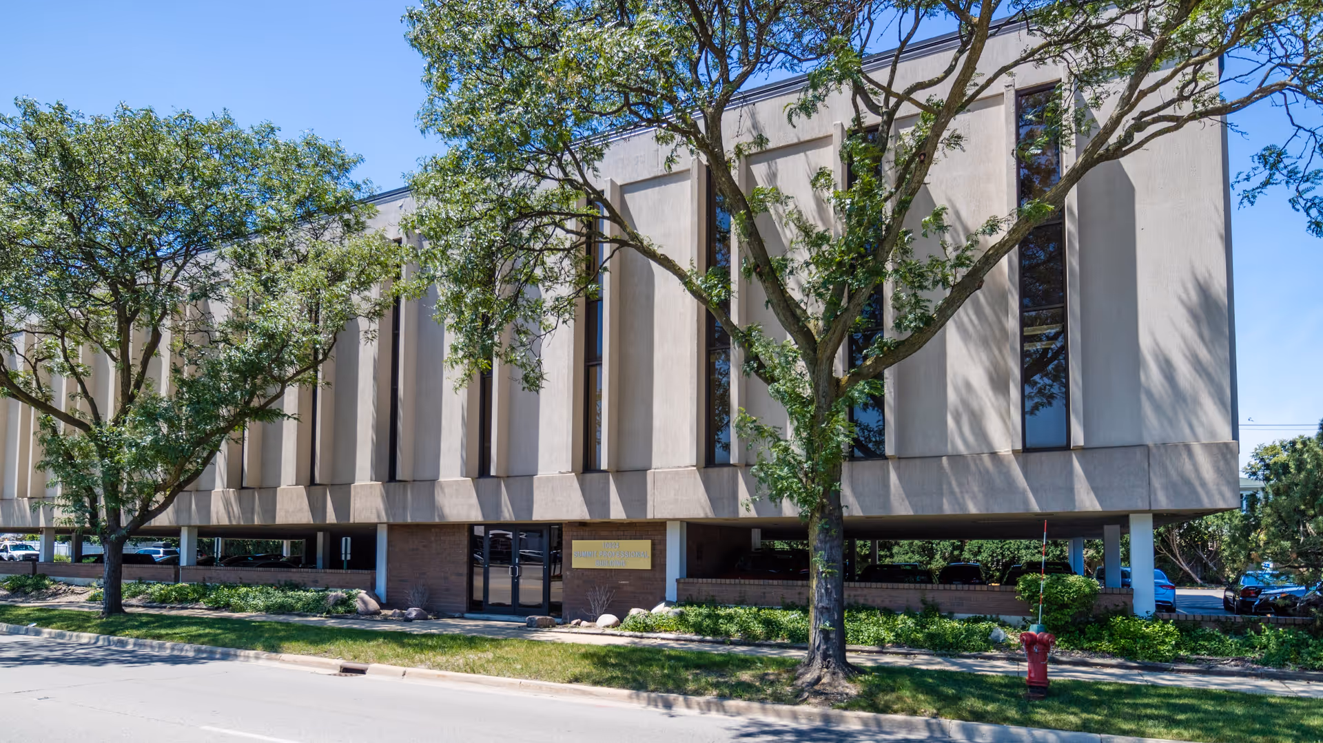 Exterior view of a SYNERGY HomeCare building with trees and a main entrance.