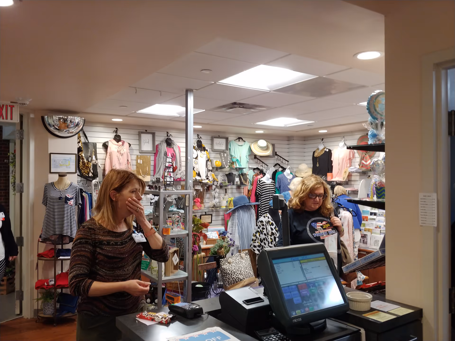 Interior of Blessing Hospital gift shop with clothing racks and a checkout counter.