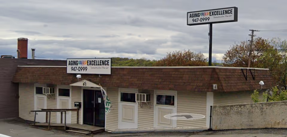Small, single-story building with Aging Excellence signage and entrance doors.