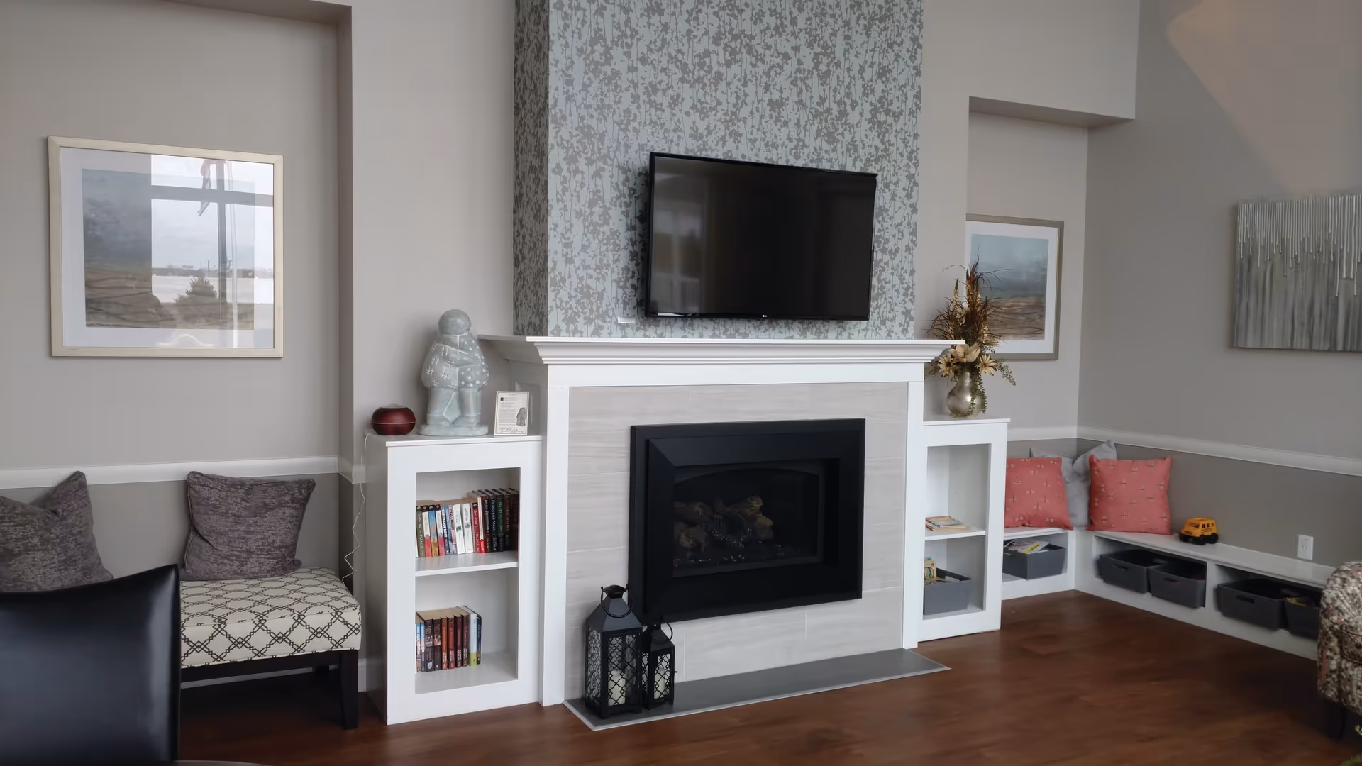 Cozy living room with a fireplace, mounted TV, and built-in shelves.