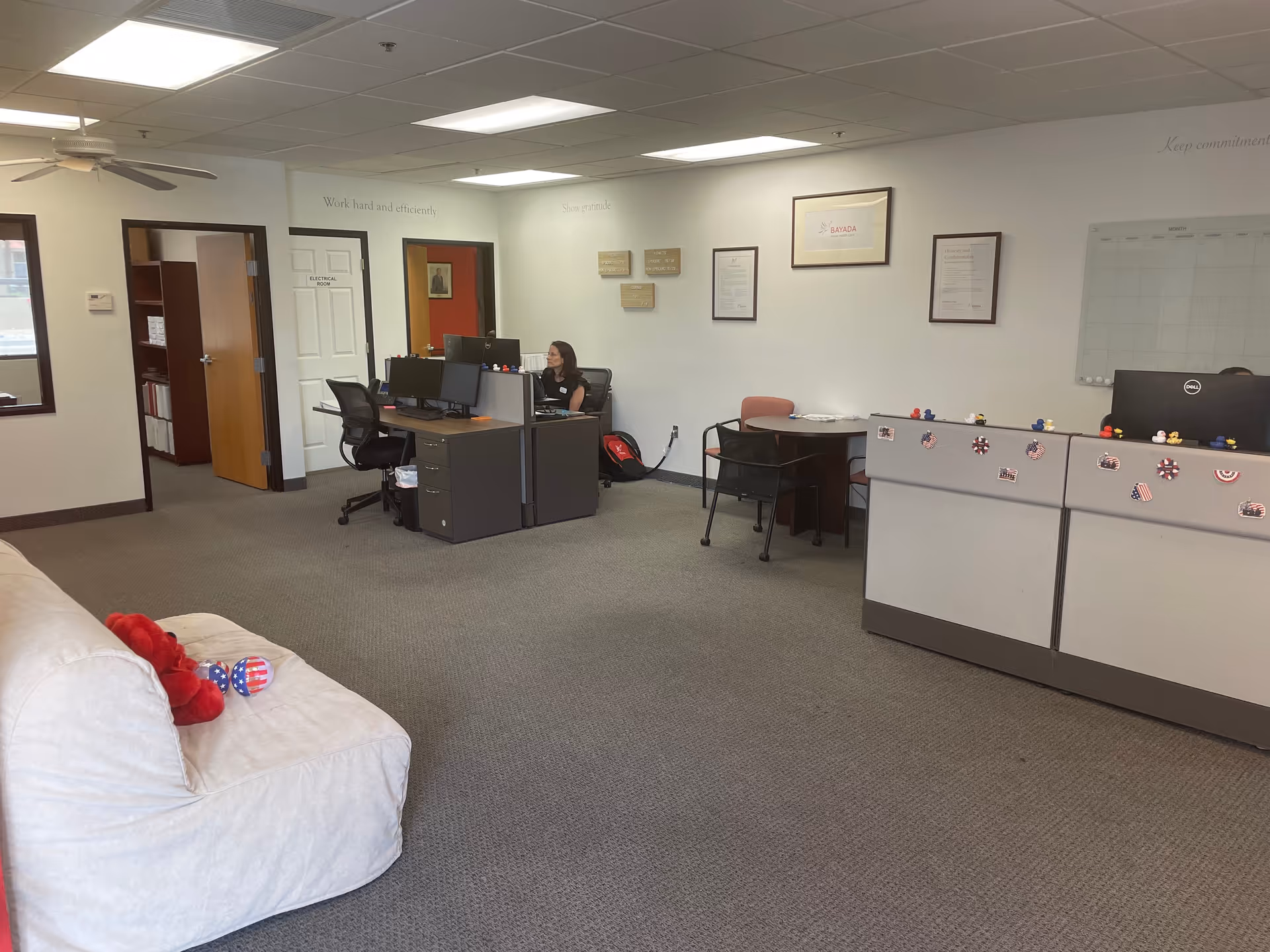 Bayada Home Health office reception with desks, cubicles, computers, and a white couch.