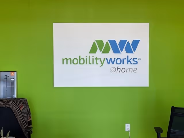 Bright green interior wall with MobilityWorks at home sign.