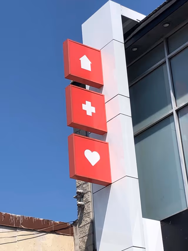 Exterior view of Elite Home Health Care sign with red blocks featuring home, cross, and heart.