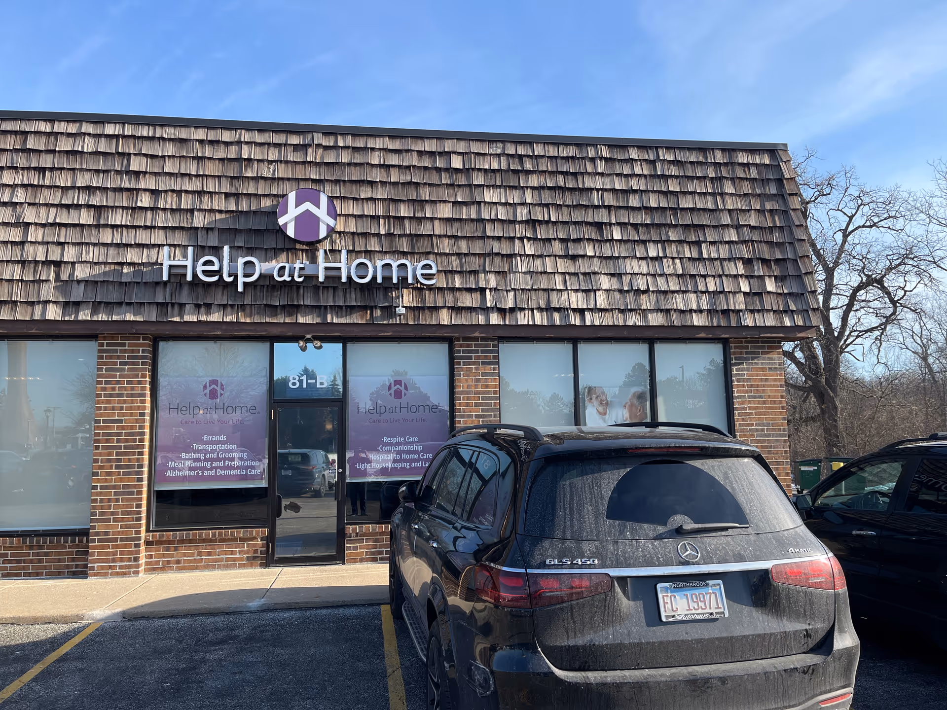 Front view of Help at Home senior care facility with parked cars.