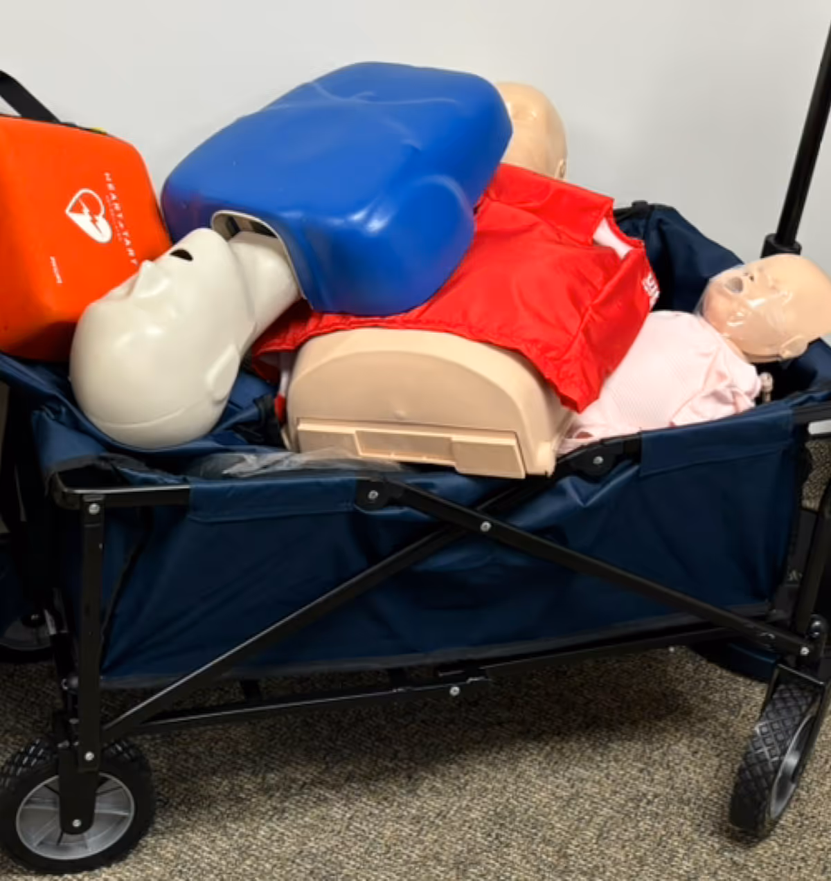 CPR training manikin and medical equipment on a rolling cart at Kay's Home Care Two.