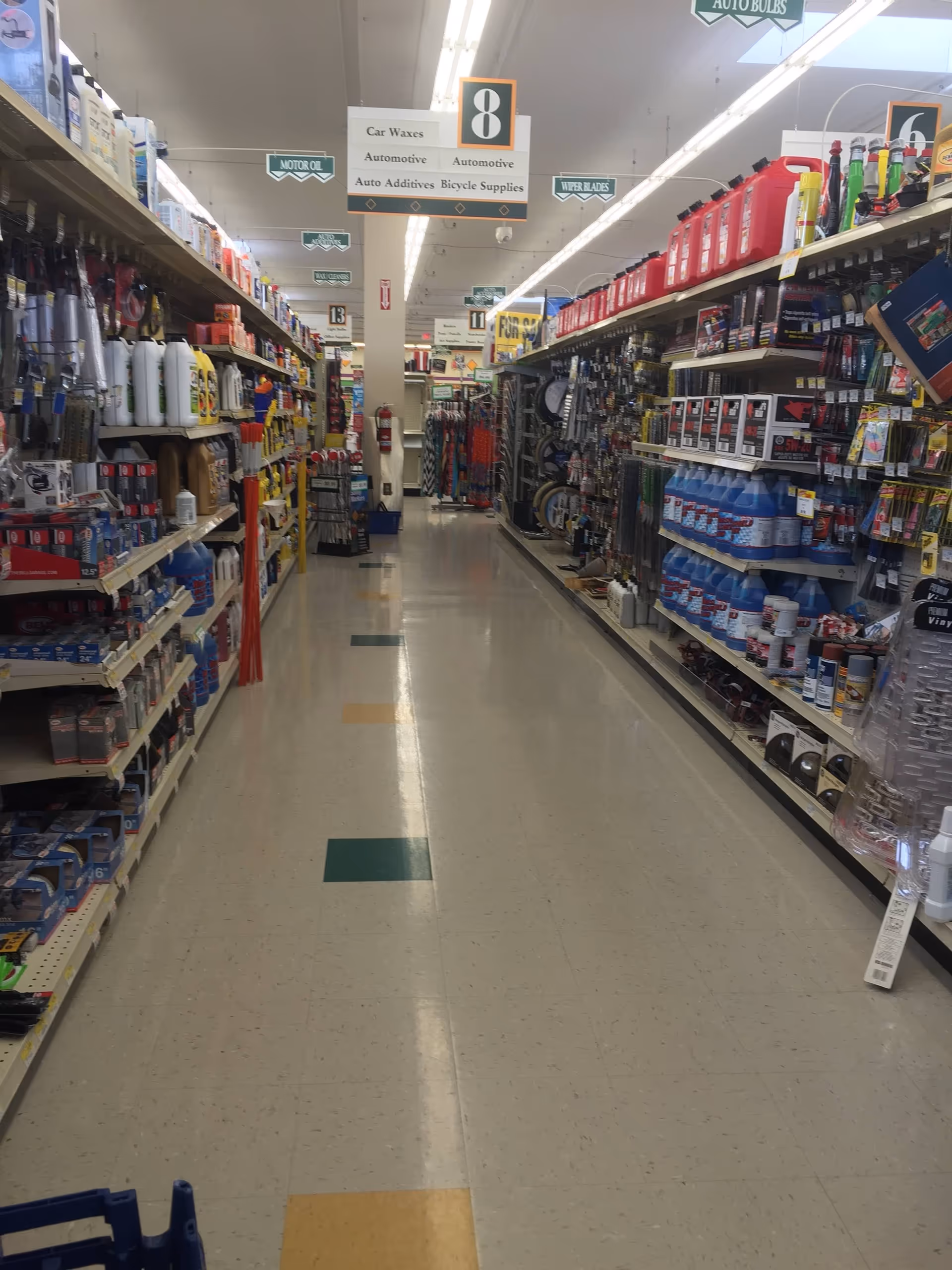 Long aisle in a discount store with shelves stocked with various products.