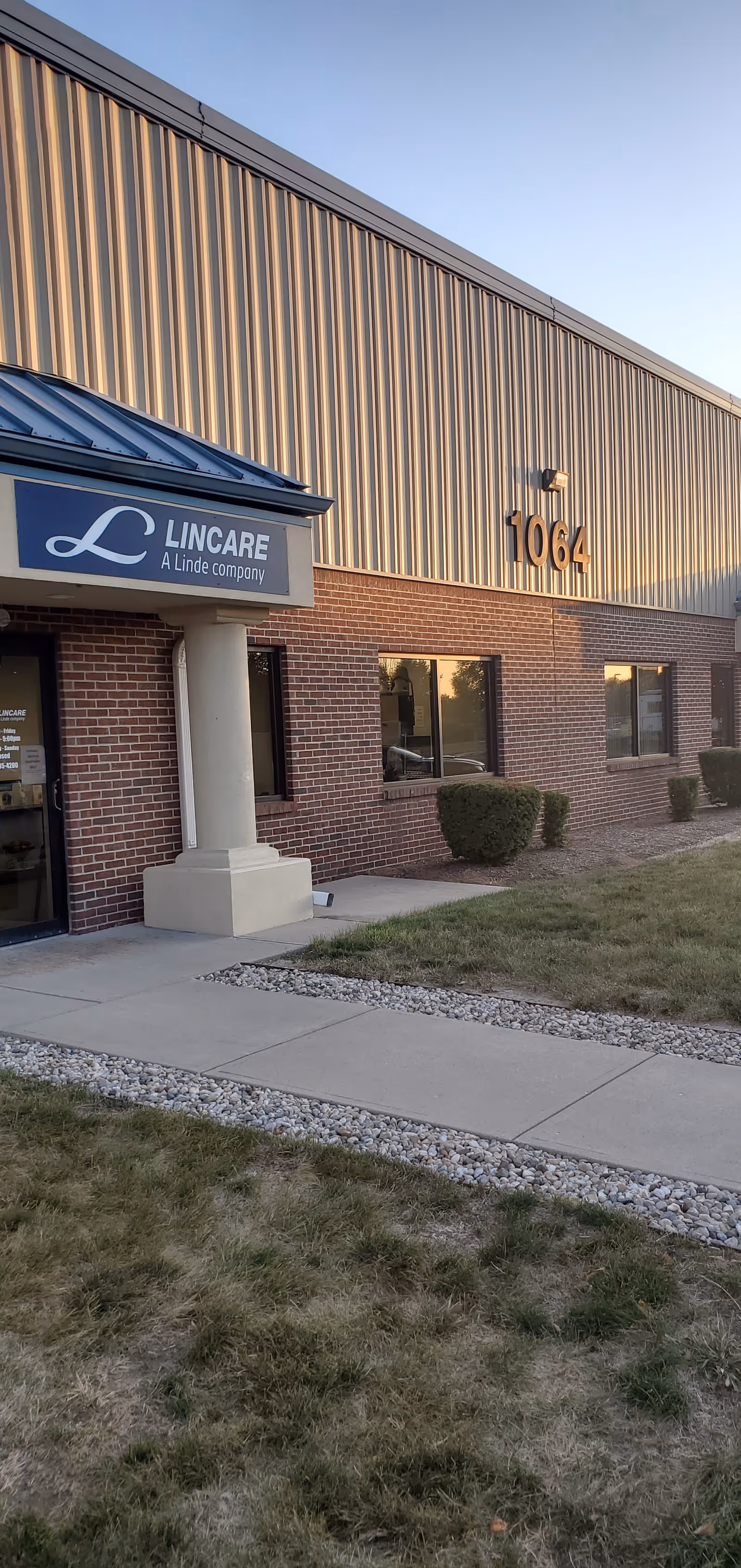 Exterior view of LINCARE facility, brick building with sign and large numbers 1064.