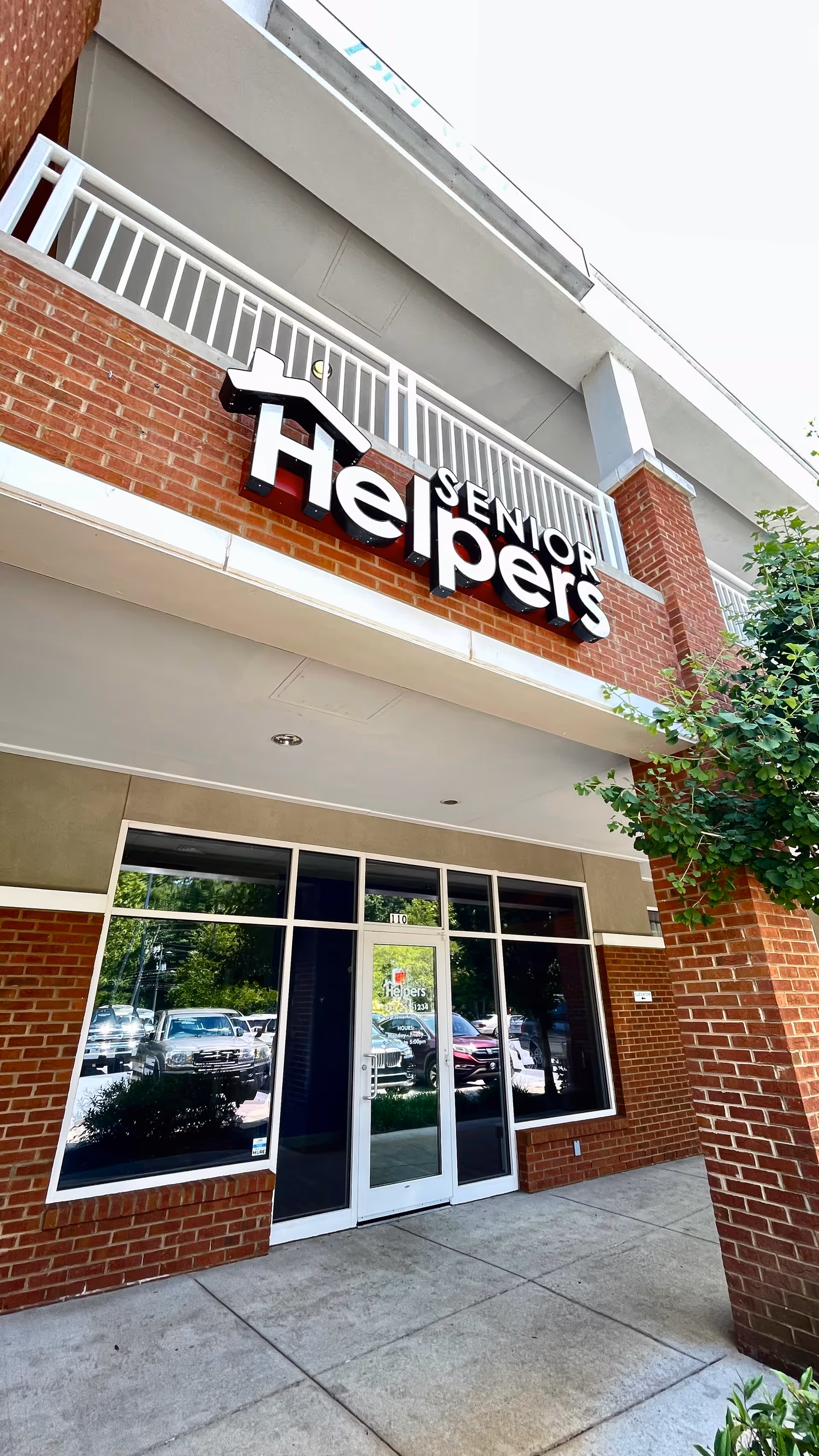 Exterior view of Senior Helpers facility entrance with brick facade and glass doors.