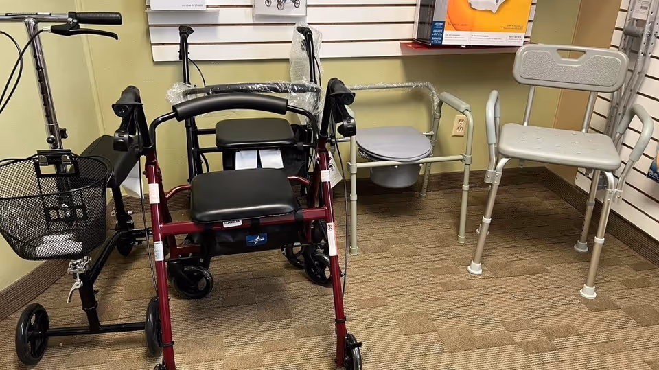 Mobility aids such as walkers and wheelchairs stored in an interior facility corner.