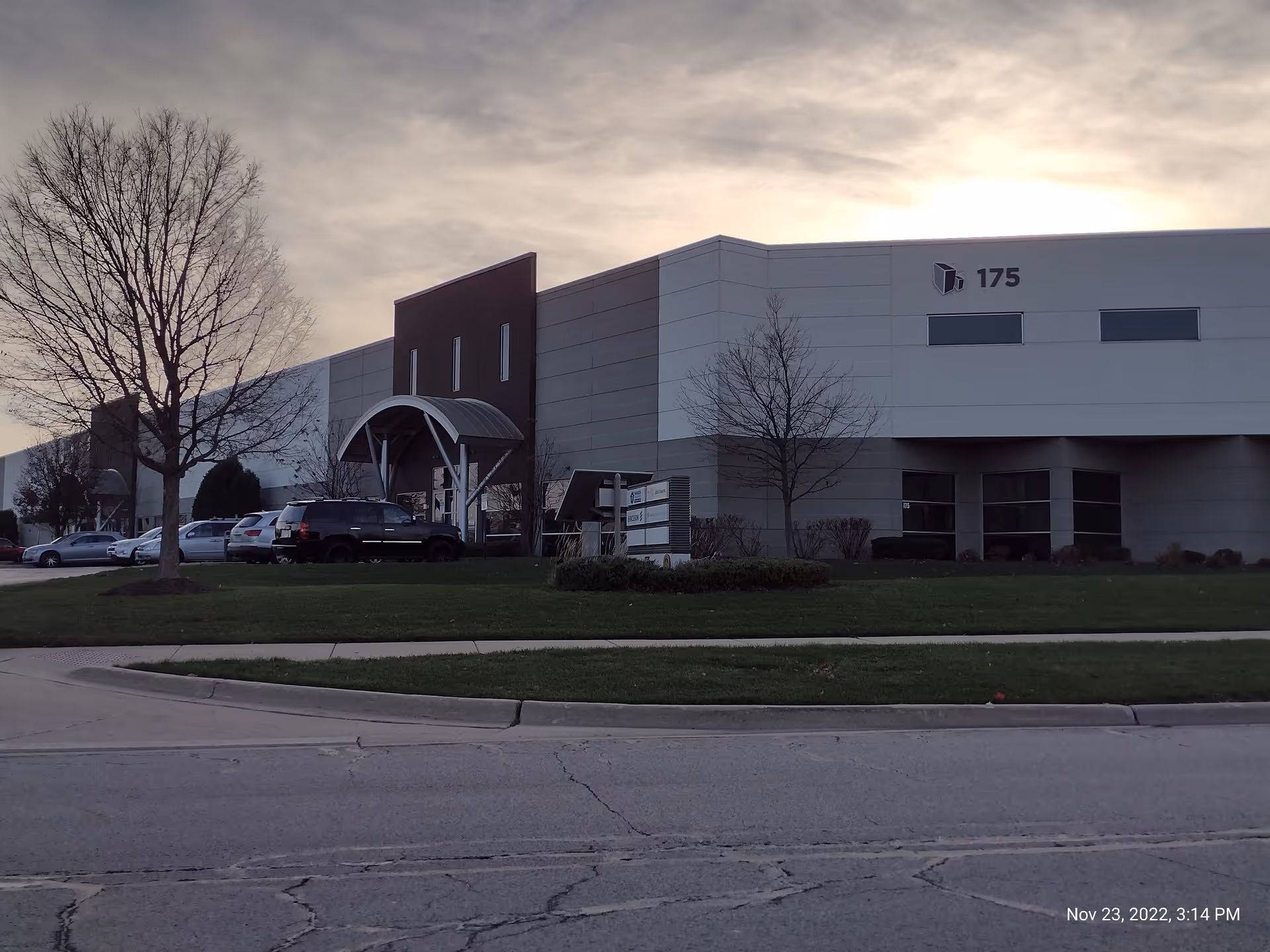 Modern medical facility exterior with entrance canopy and parking lot.