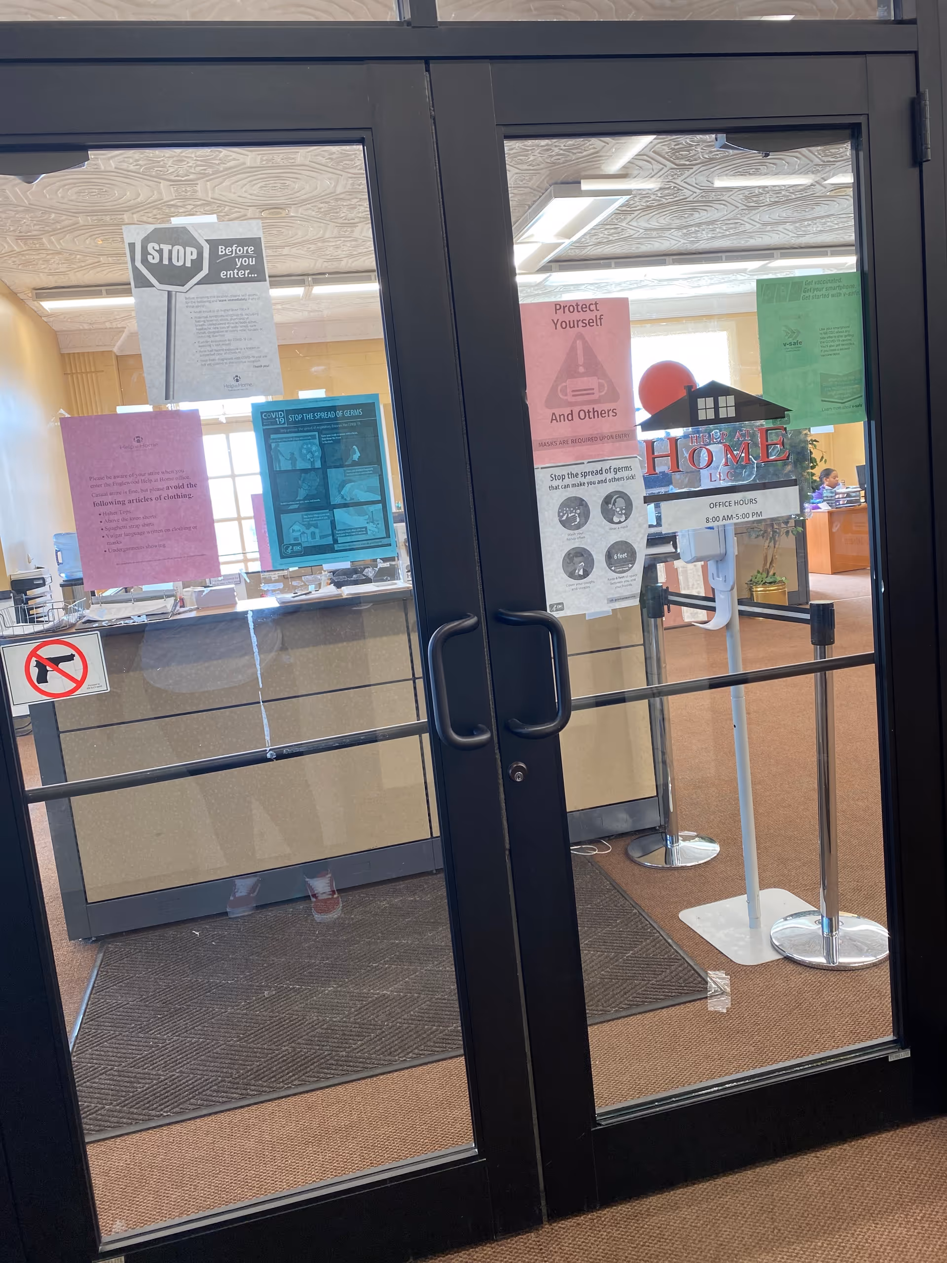 Interior lobby visible through glass doors with posted notices and signs.