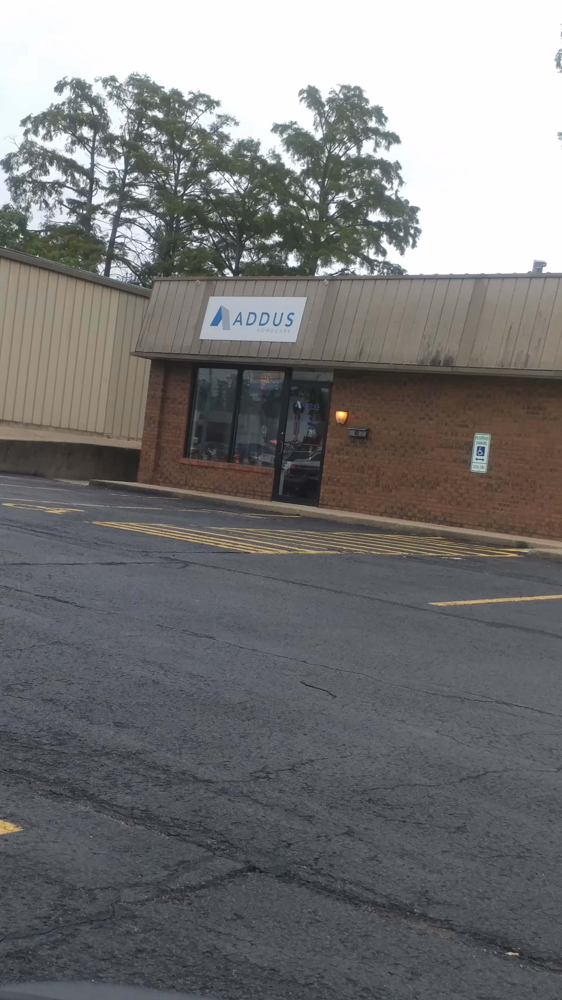 Exterior view of an Addus HomeCare facility with entrance door and parking lot.