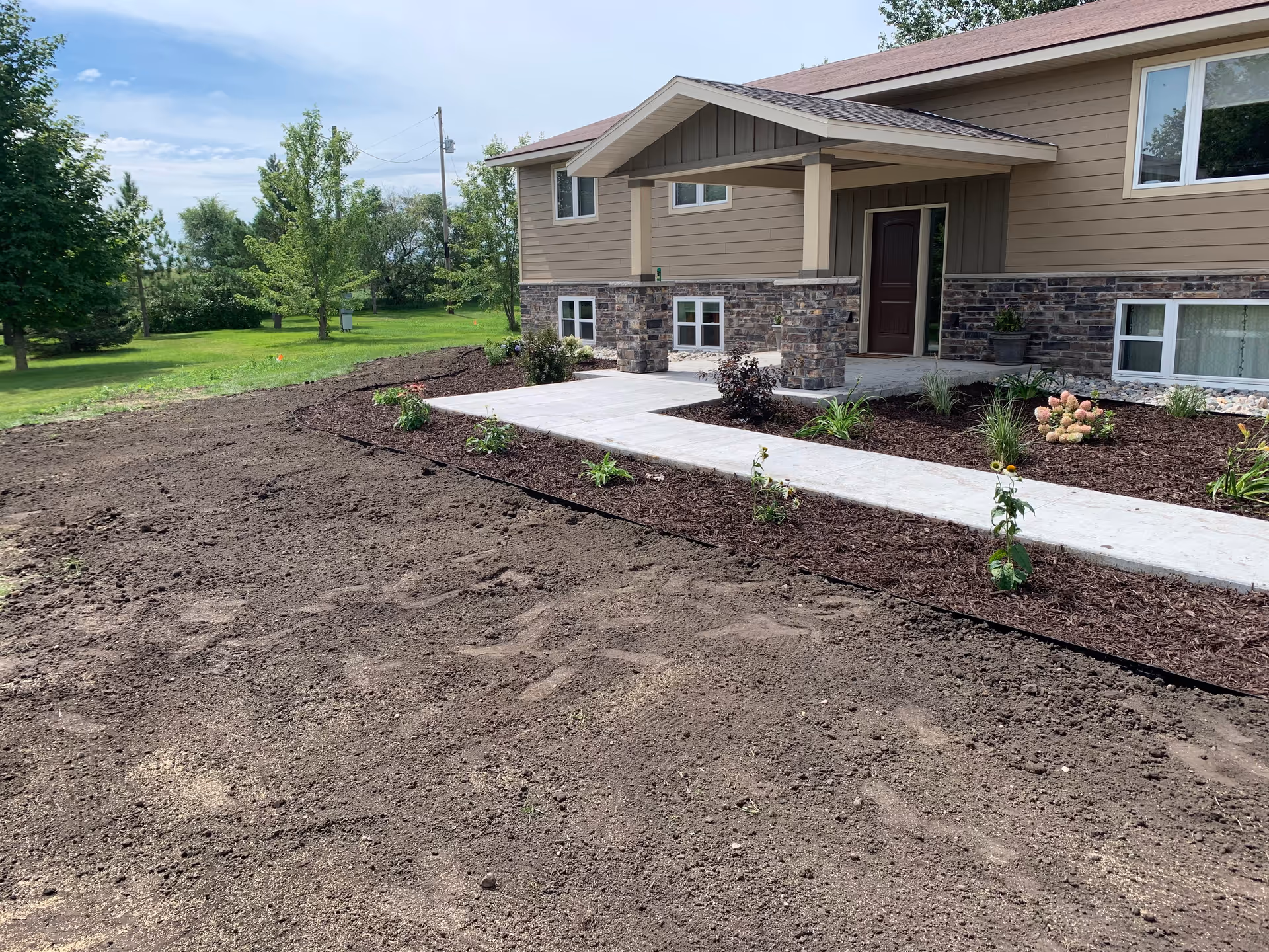 Front view of Harmony Home Health Care building with walkway and landscaped mulch beds.