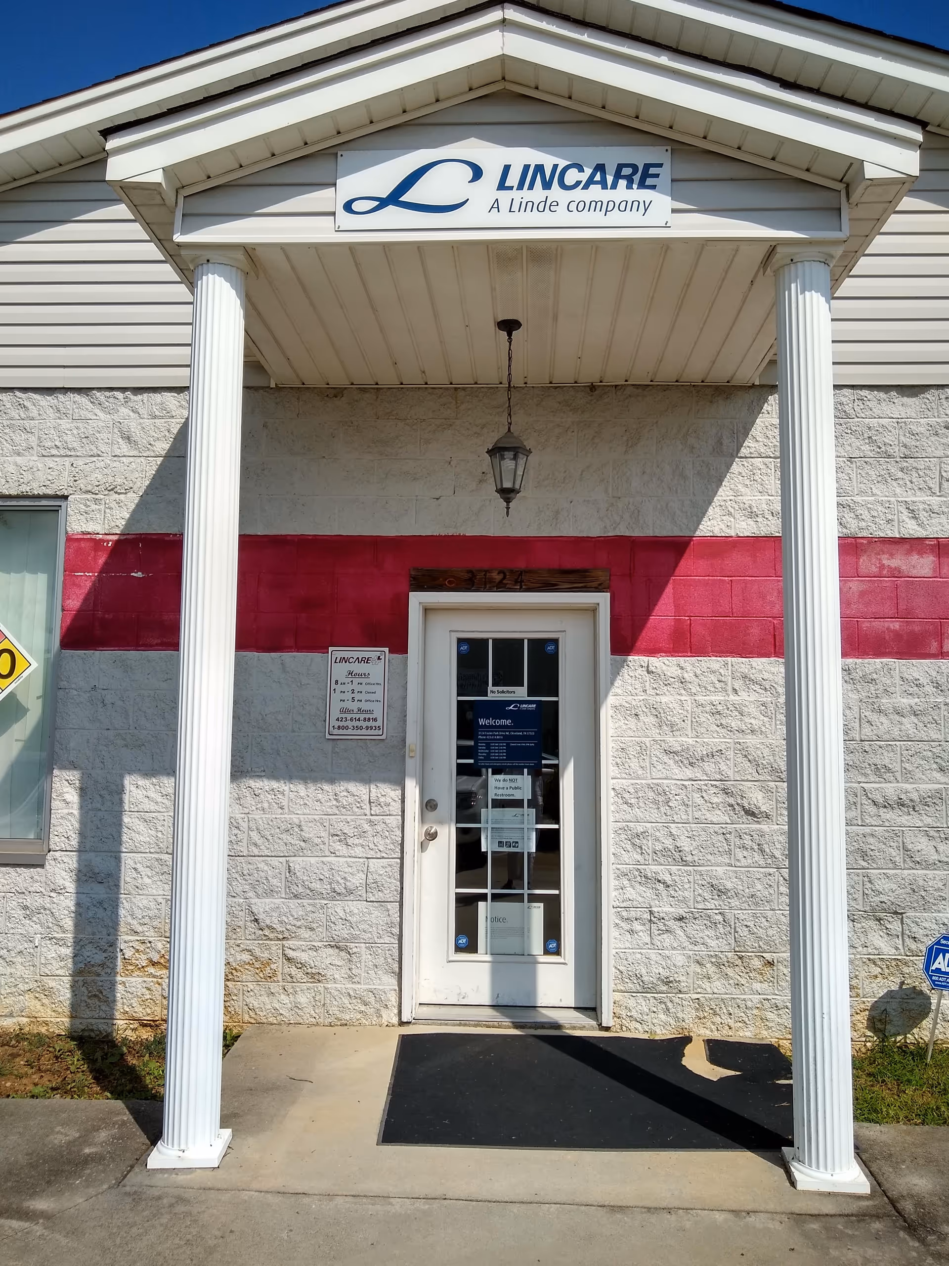 Exterior front entrance of a LINCARE facility with white columns.