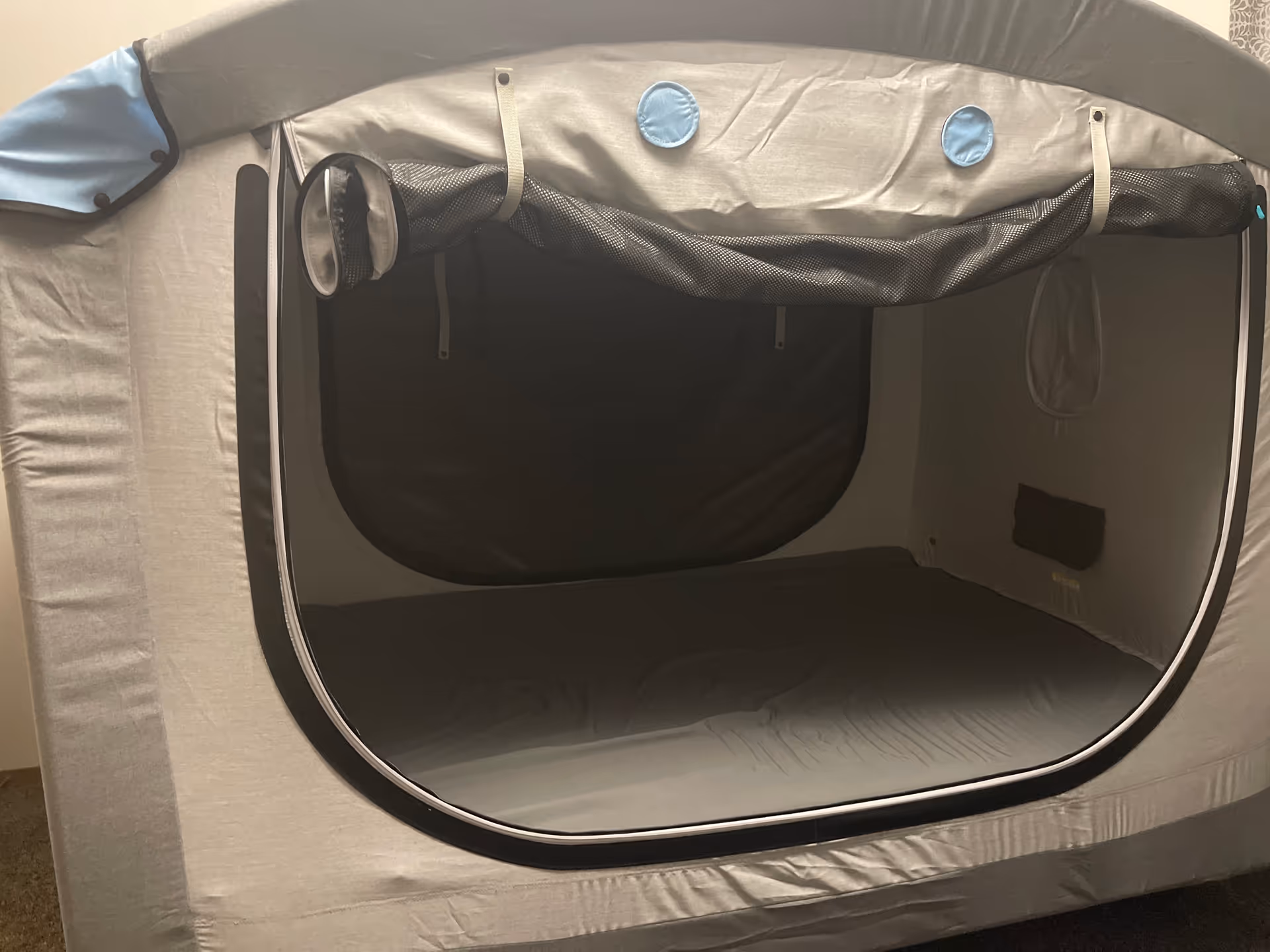 Indoor privacy tent over a bed in a small residential room.