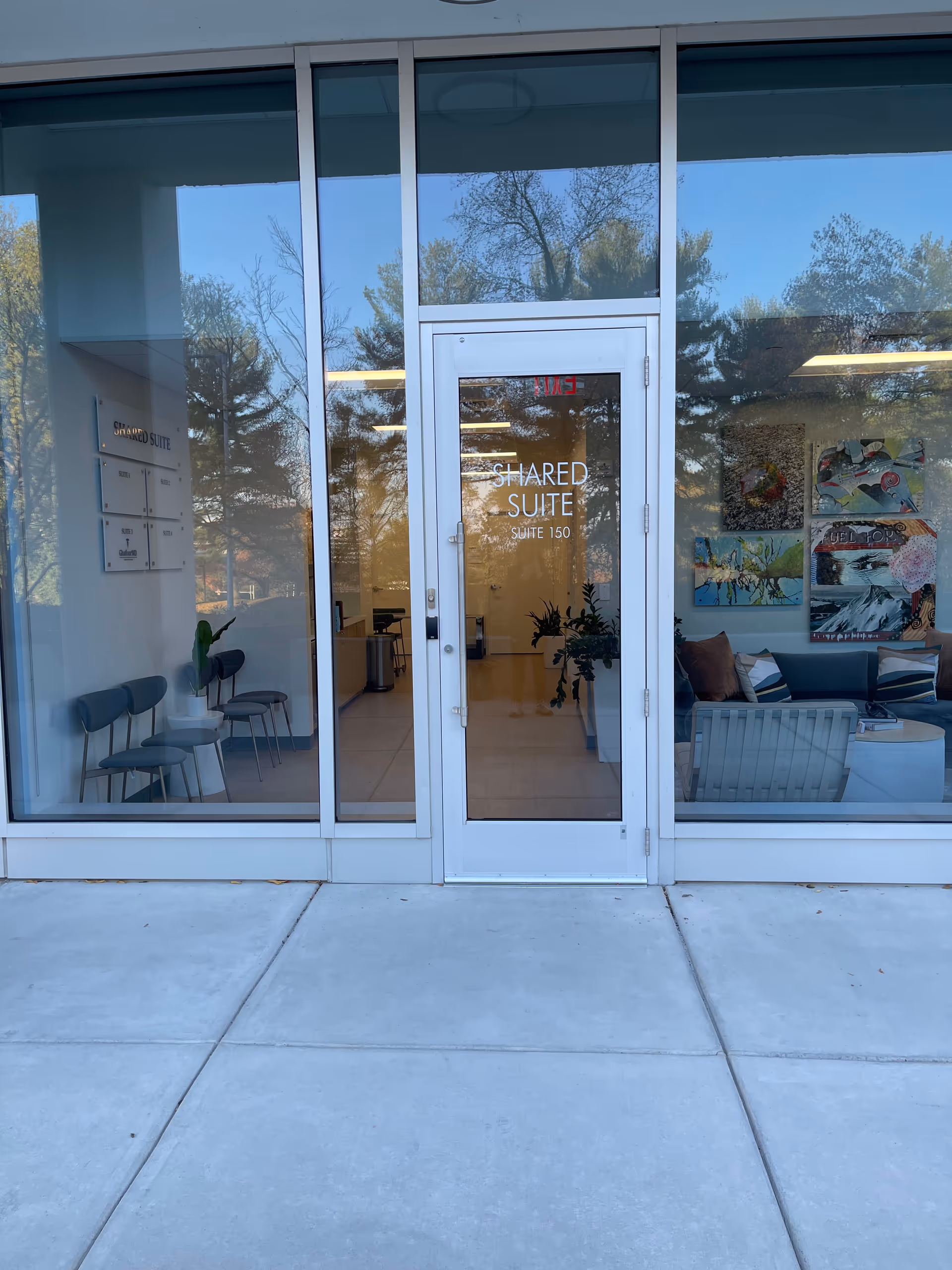 Glass entrance door labeled Shared Suite opens to a lobby with seating and art.