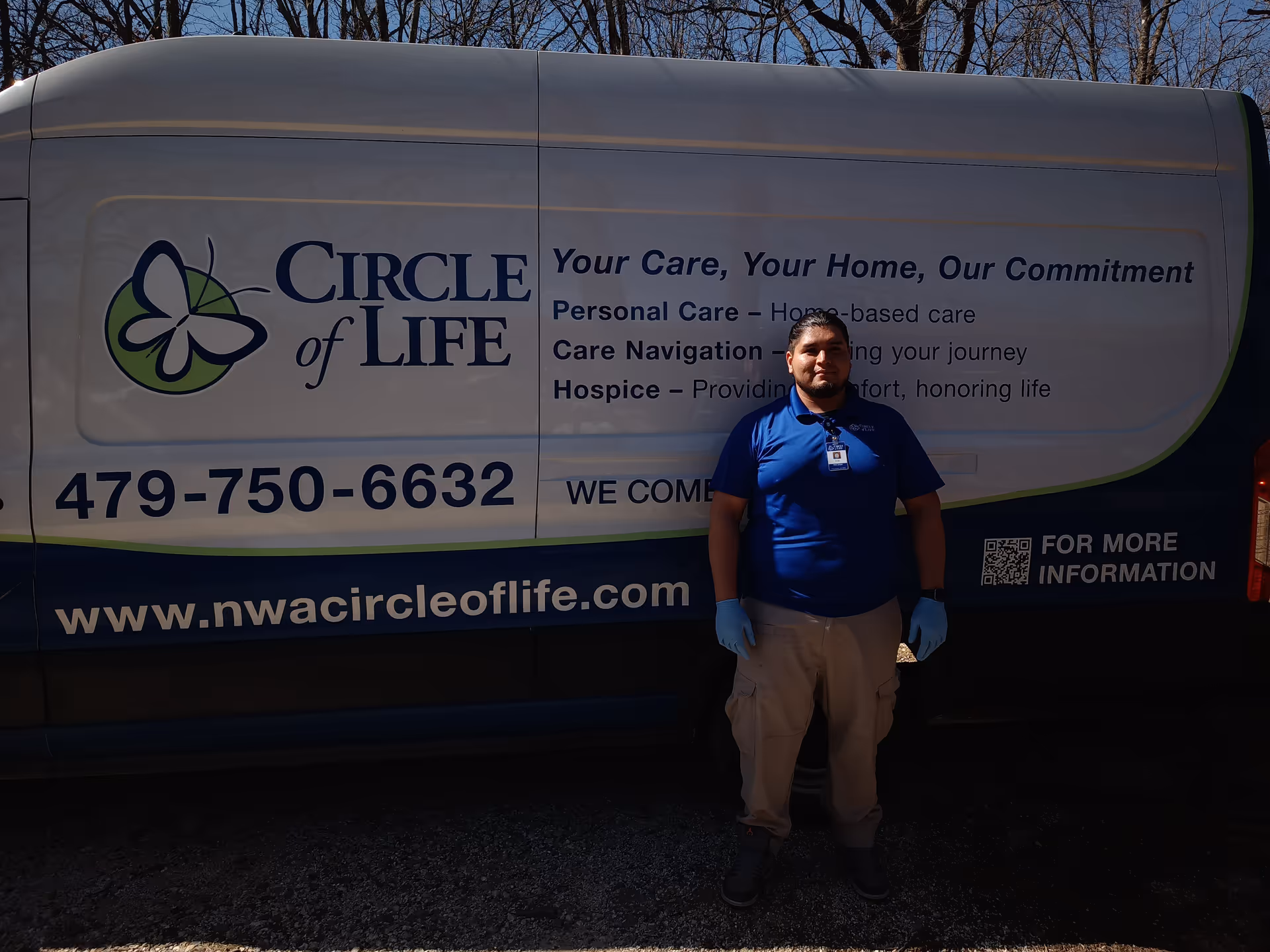 Person in blue shirt stands beside a Circle of Life service van with branding.