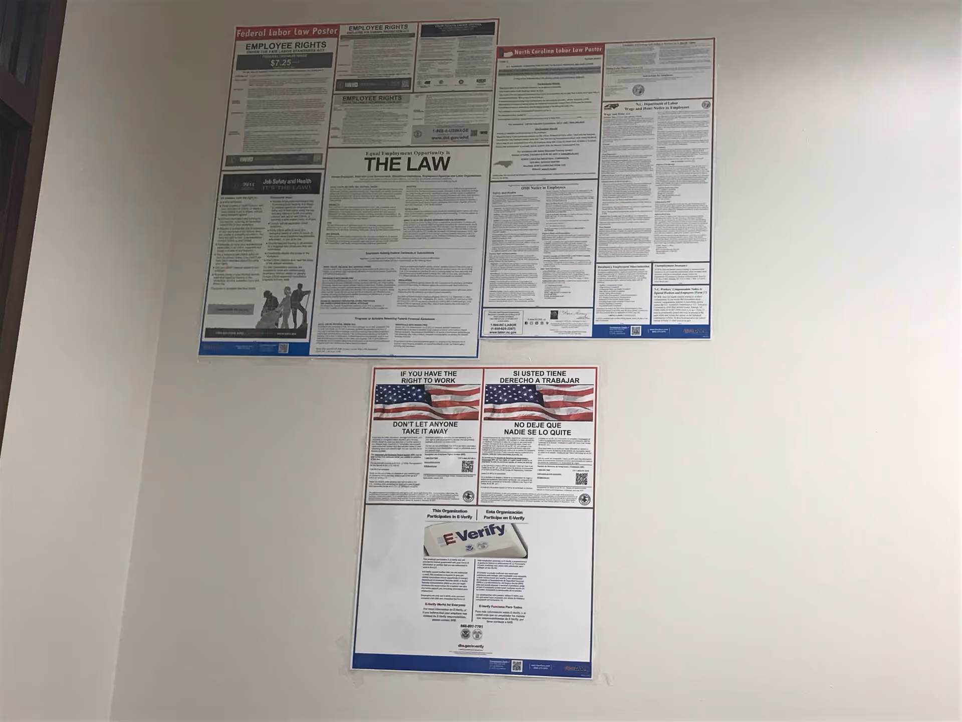 Interior wall with multiple posted notices and informational flyers.