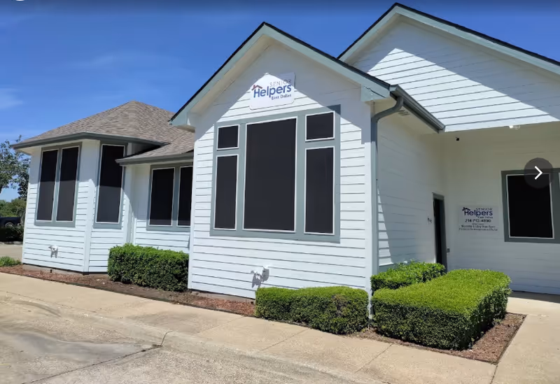 White senior living facility exterior with large windows and a Senior Helpers sign.