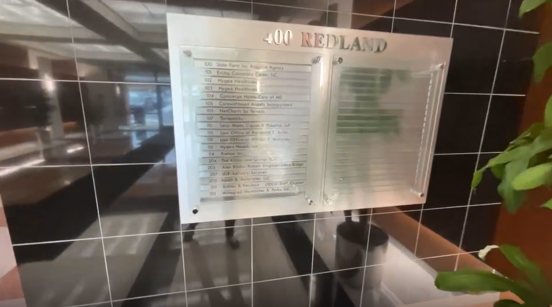 Interior lobby wall with a metallic directory plaque reading 400 Nedland.