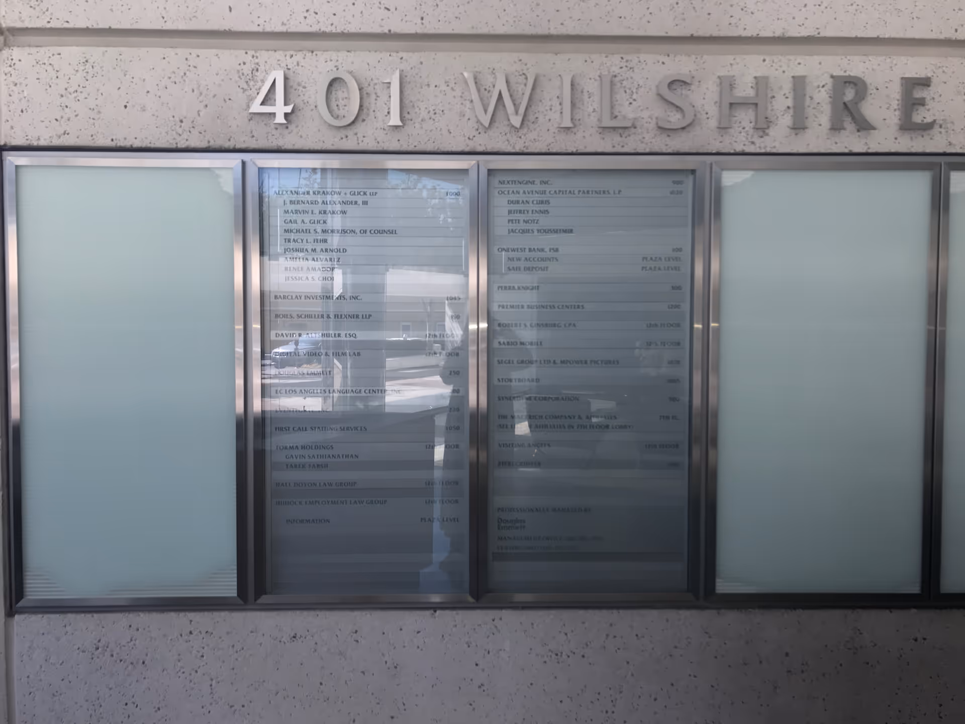 Exterior view of a building facade with 401 Wilshire and a directory panel.