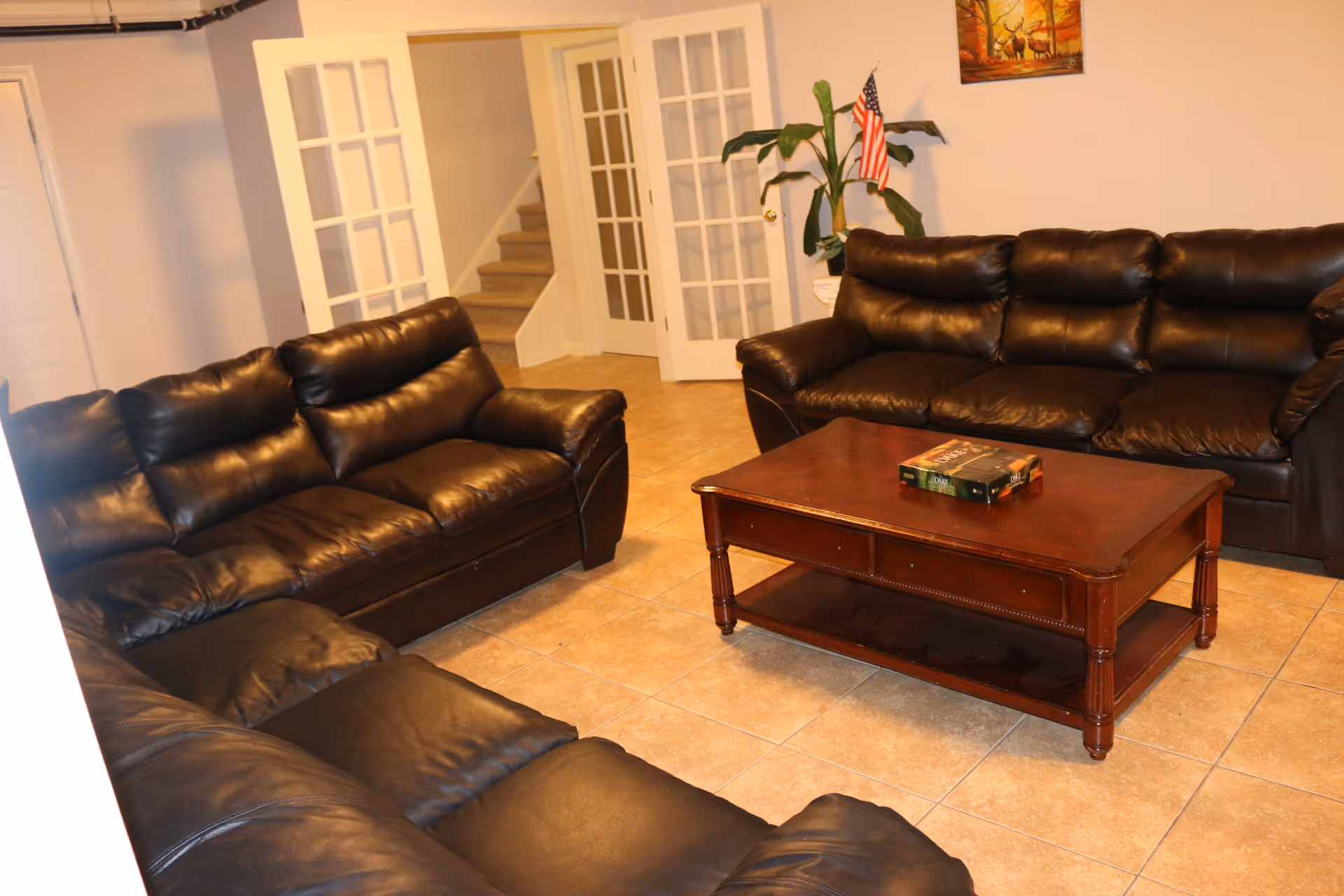 Leather couches surround a wooden coffee table in a family-style living room.