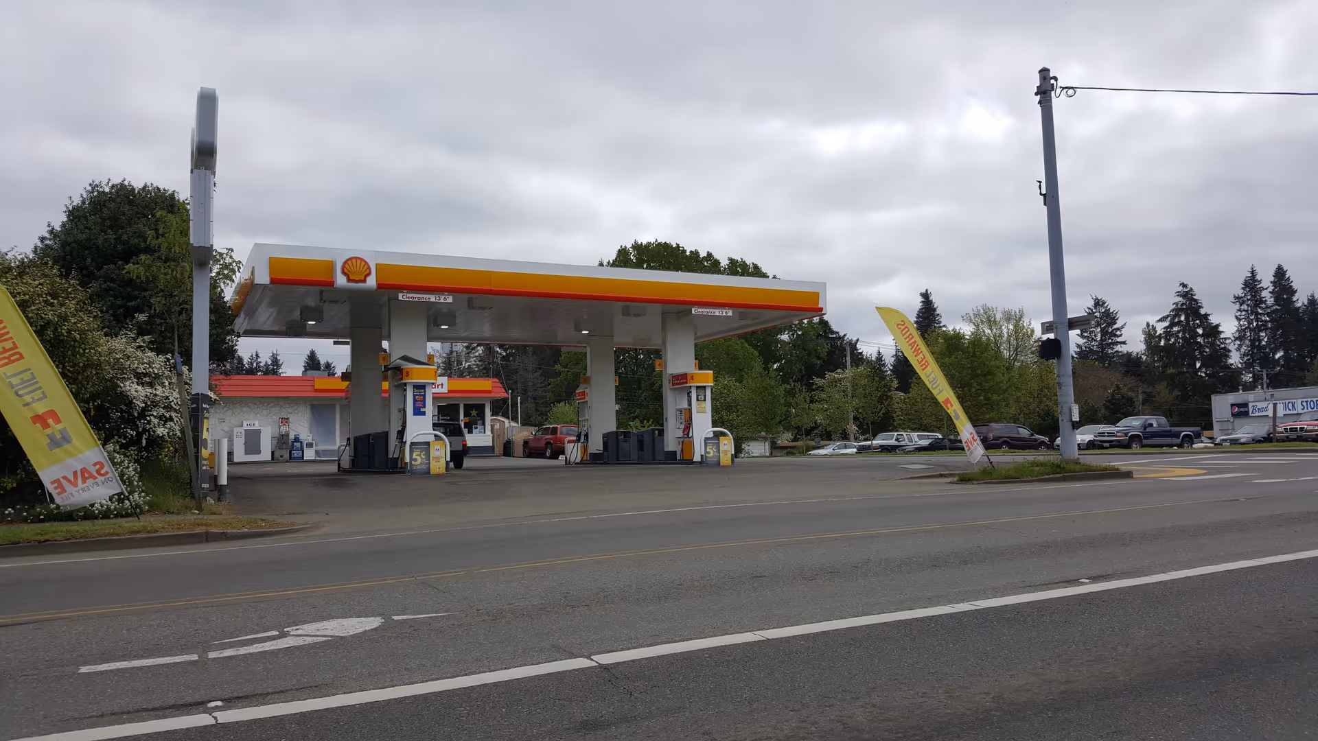 Shell gas station with multiple pumps under a canopy along a street.