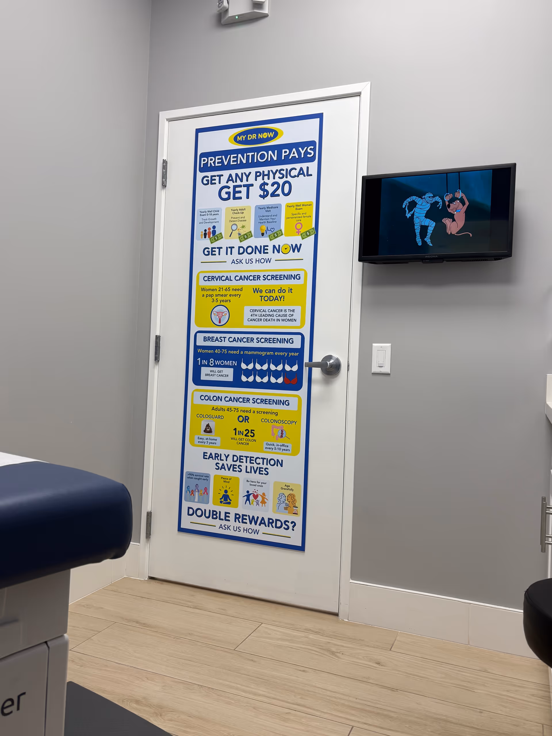 Interior room showing a door with a large health poster and a wall TV.