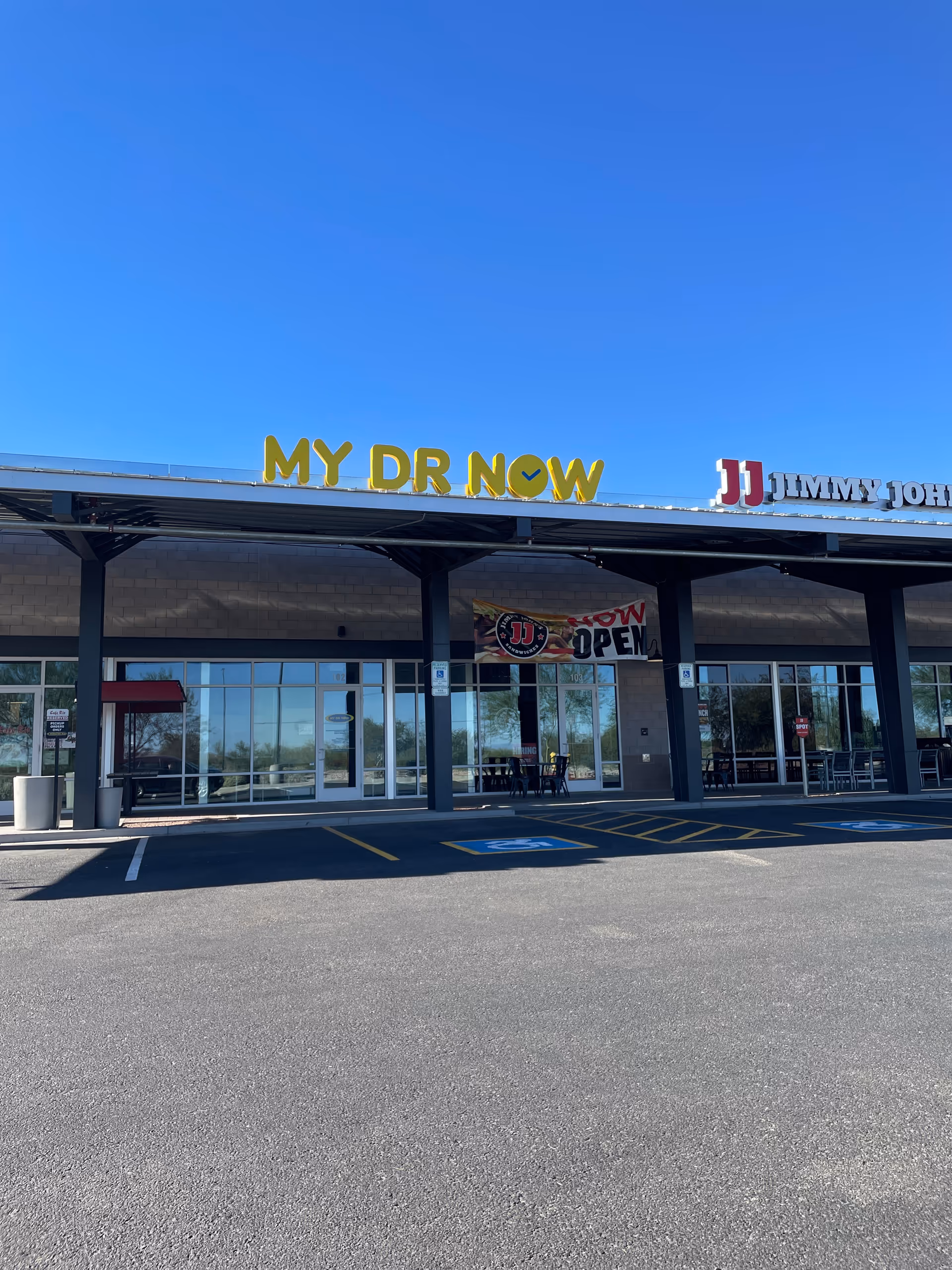 Exterior view of MY DR NOW storefront with glass doors and parking.