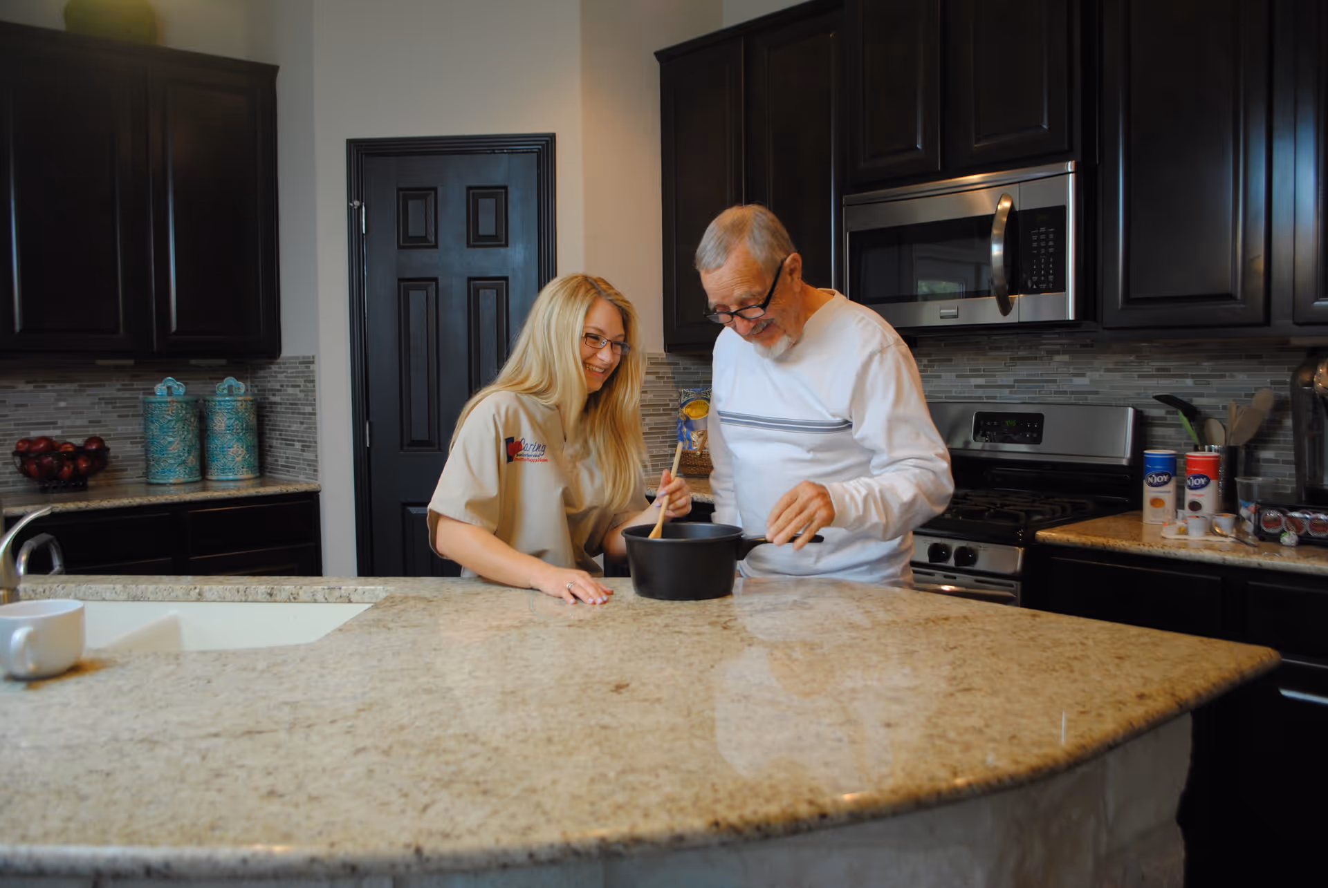 Two people cook together at a modern kitchen island.