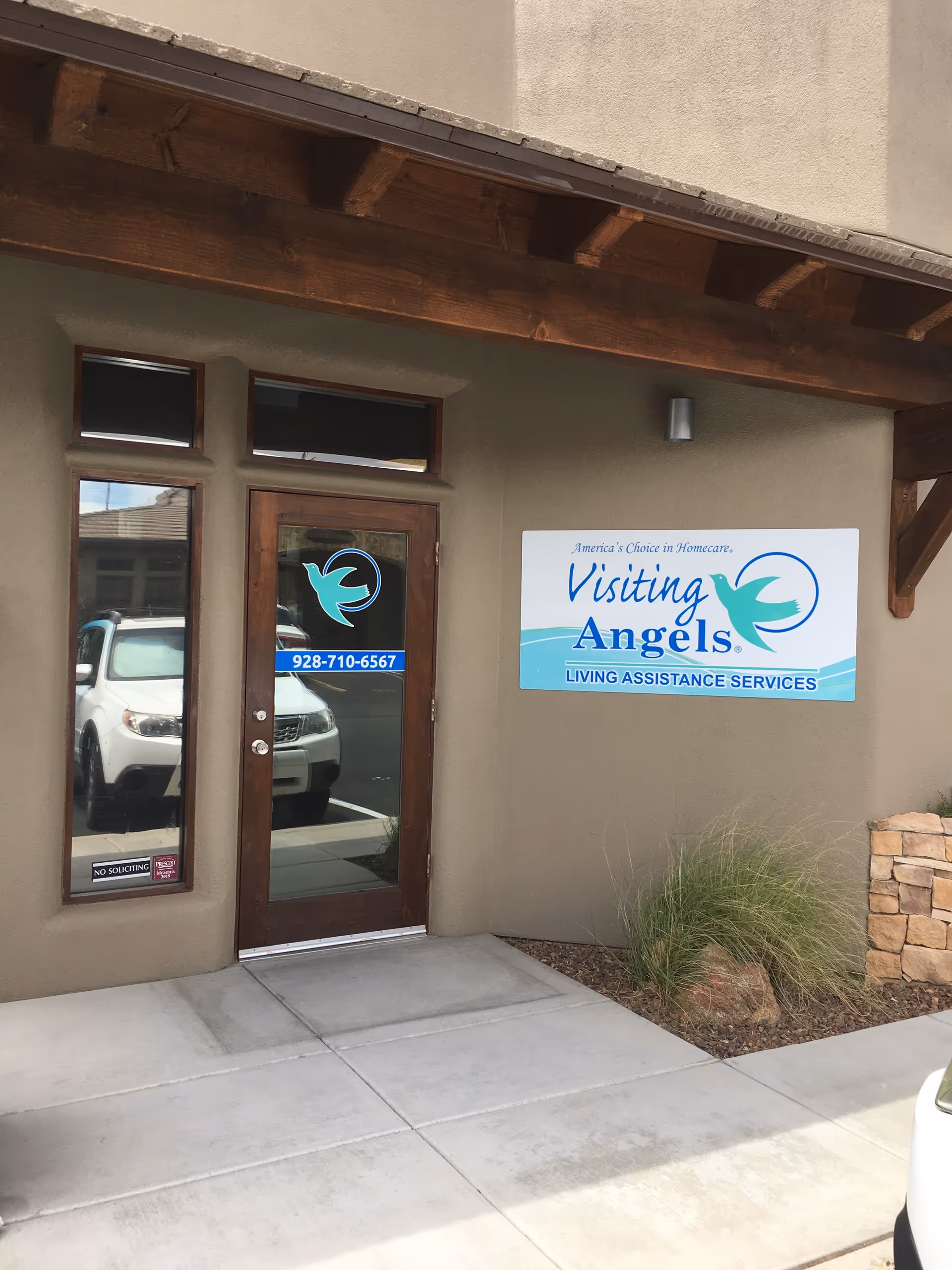Exterior view of Visiting Angels senior home care entrance with sign and glass doors.