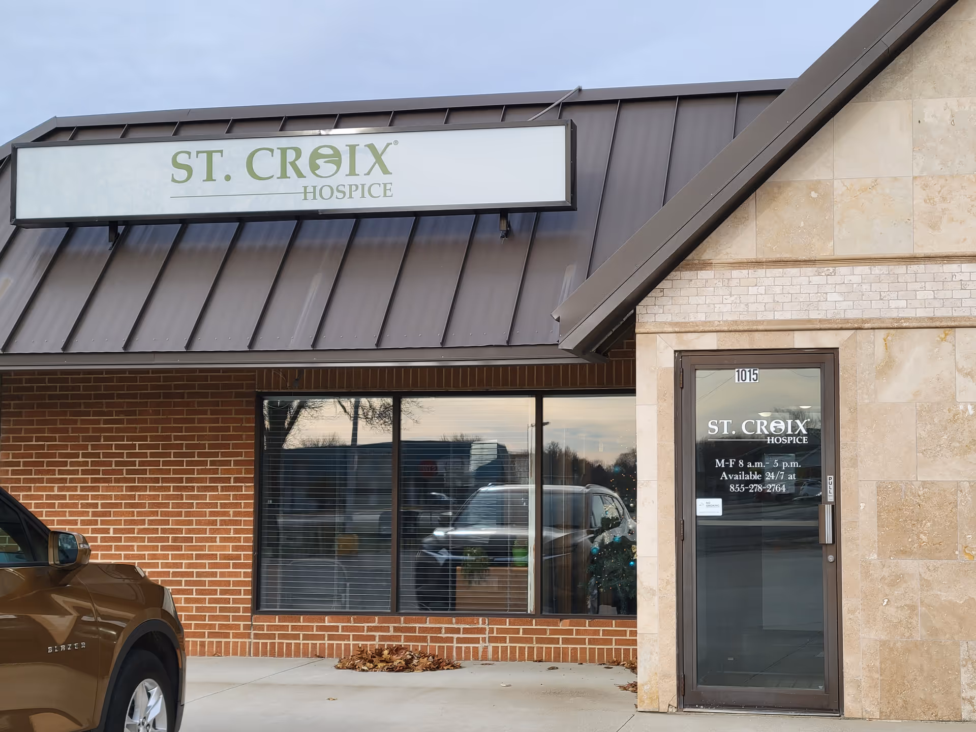 Exterior view of St. Croix Hospice facility with sign, windows, and a parked car.