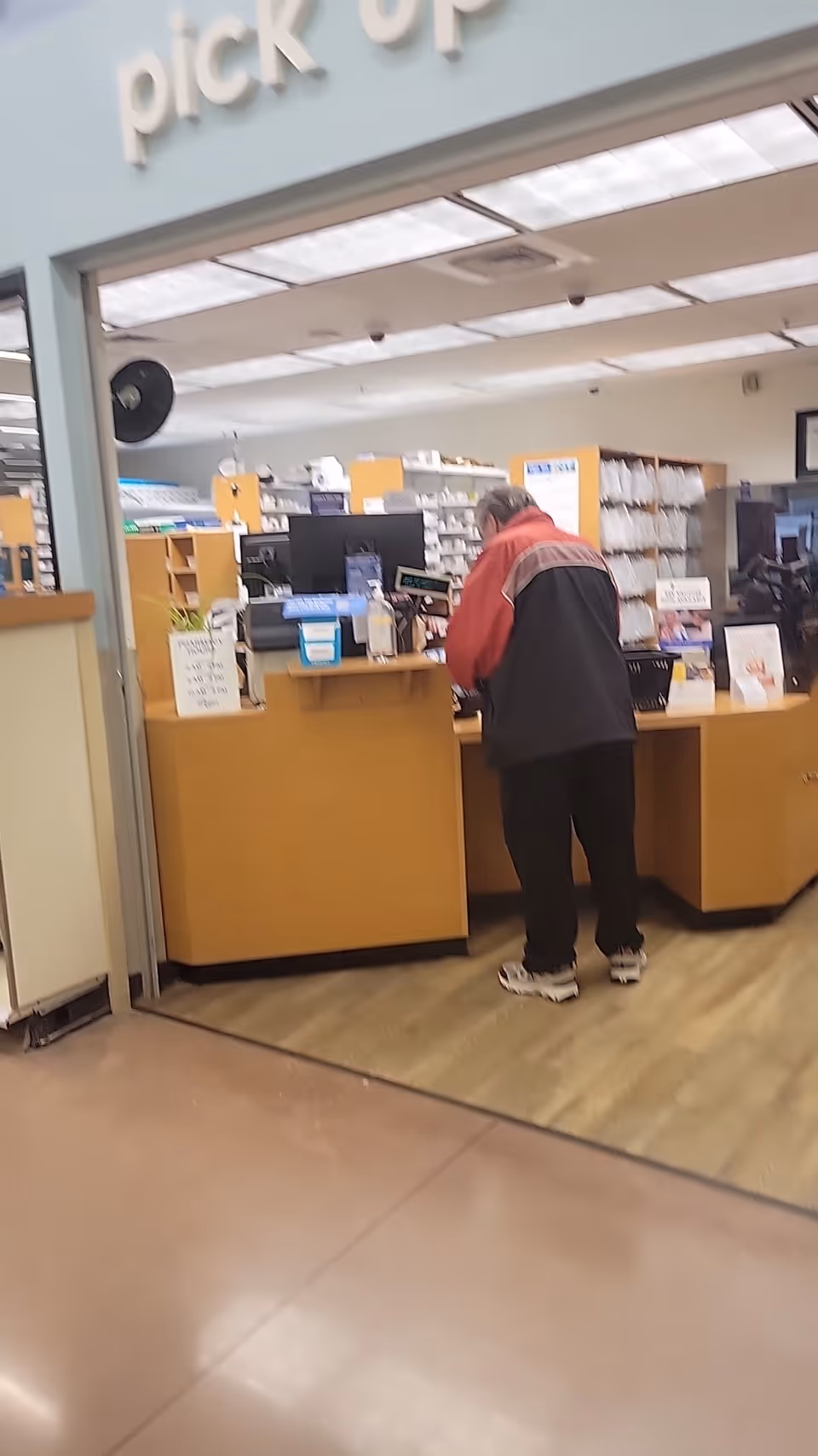 Man at Kroger Pharmacy pickup counter inside a senior living facility